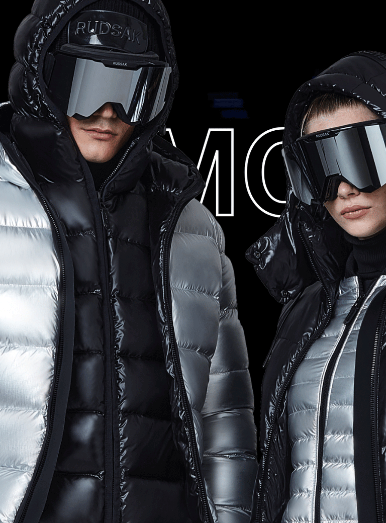 Two models in shiny winter jackets and large futuristic sunglasses pose against a black background with “CYBER MONDAY” text partially visible behind them. One jacket is silver, the other is black.