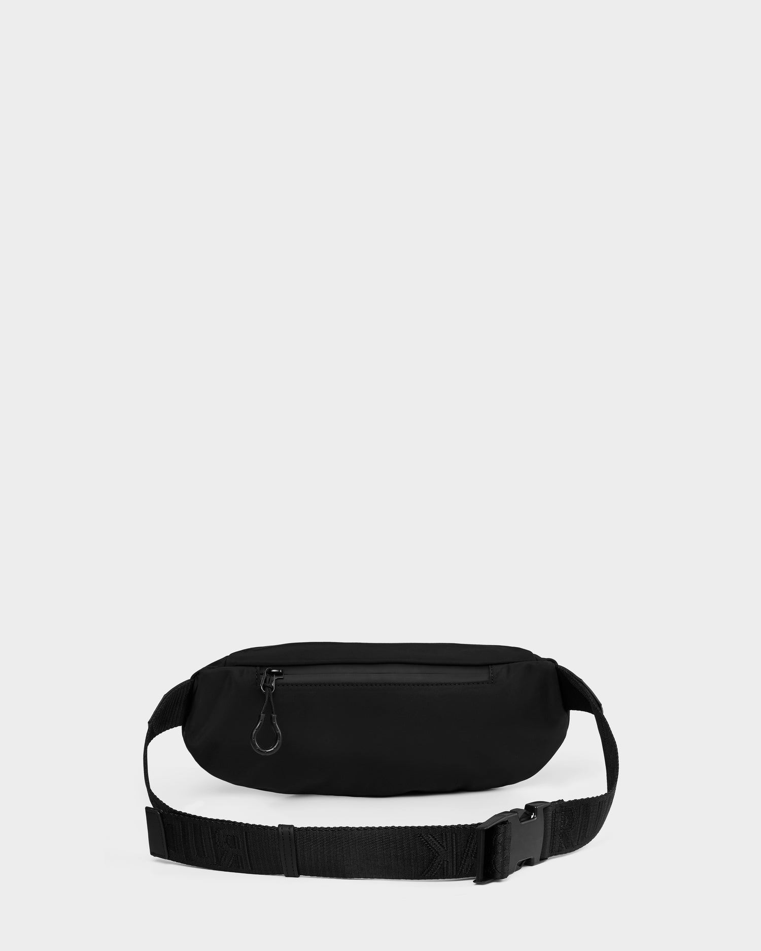 The Rudsak RILO - 9326000 Black waist bag features a zippered front pocket and adjustable strap with plastic buckle, shown on a plain light gray background.