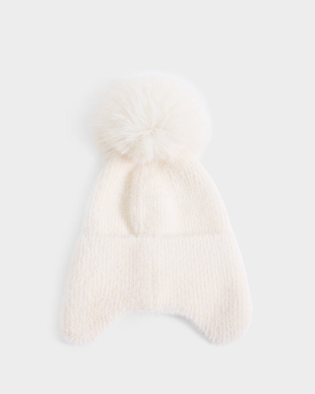 The Rudsak ICE - 8426519 Vanilla is a soft, white knit winter hat featuring a large, fluffy pom-pom on top and cozy ear flaps, showcased against a plain light background.