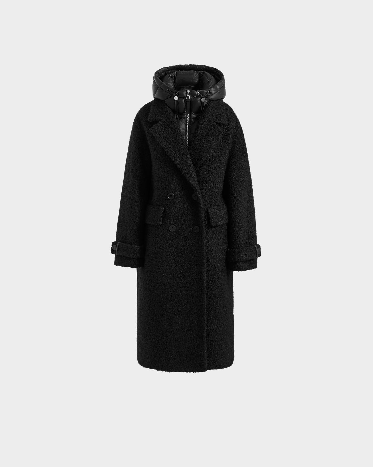 The Rudsak ARABELLA - 8125621 Black is a long black textured women’s overcoat with a quilted hood, double-breasted buttons, front flap pockets, and belted cuffs—shown on a plain light gray background.