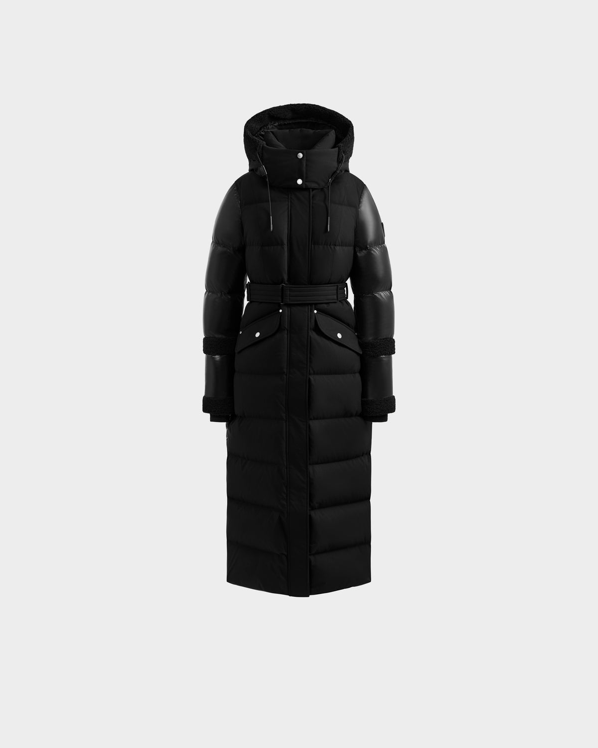 The Rudsak AUDREY XL - 8125601 Black/Black is a maxi-length down puffer jacket with a hood, belted waist, snap-button closures, quilted sections, two flap front pockets, and black cuffs.