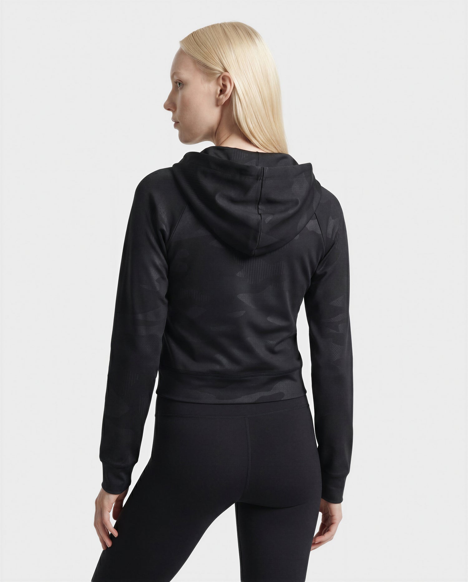A woman with straight blonde hair, seen from behind against a plain white background, is wearing the Rudsak SAMMY - L523014T Top in Camouflage Black.