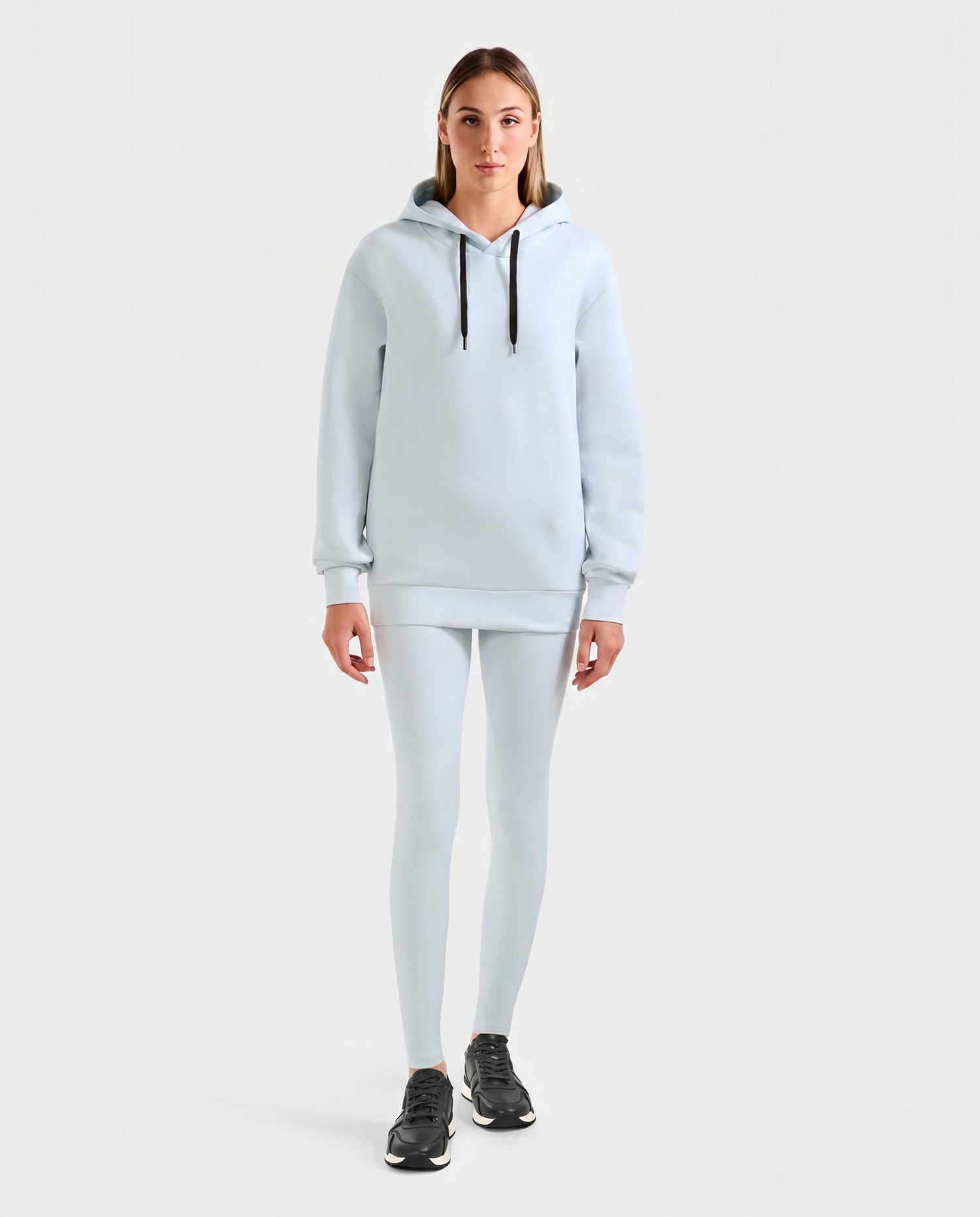 A person faces forward wearing the Rudsak LEROY - U525509 Sky Blue W cotton-blend hoodie with matching leggings and black sneakers, set against a plain light gray background.