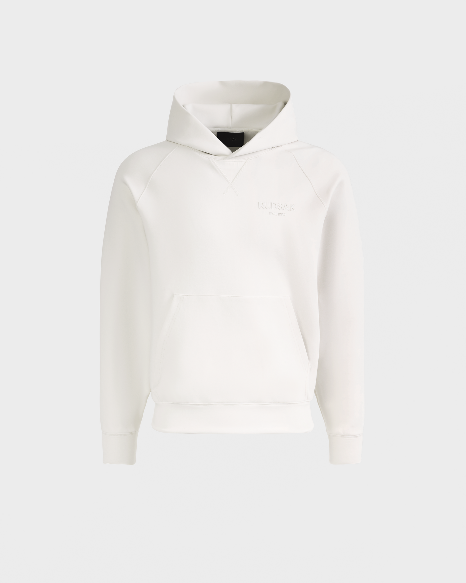 The Rudsak BARRY - 9524011 Vanilla W is a unisex white hoodie with long sleeves, a front pocket, and subtle stitching. Its simple, clean design is shown against a light gray background.