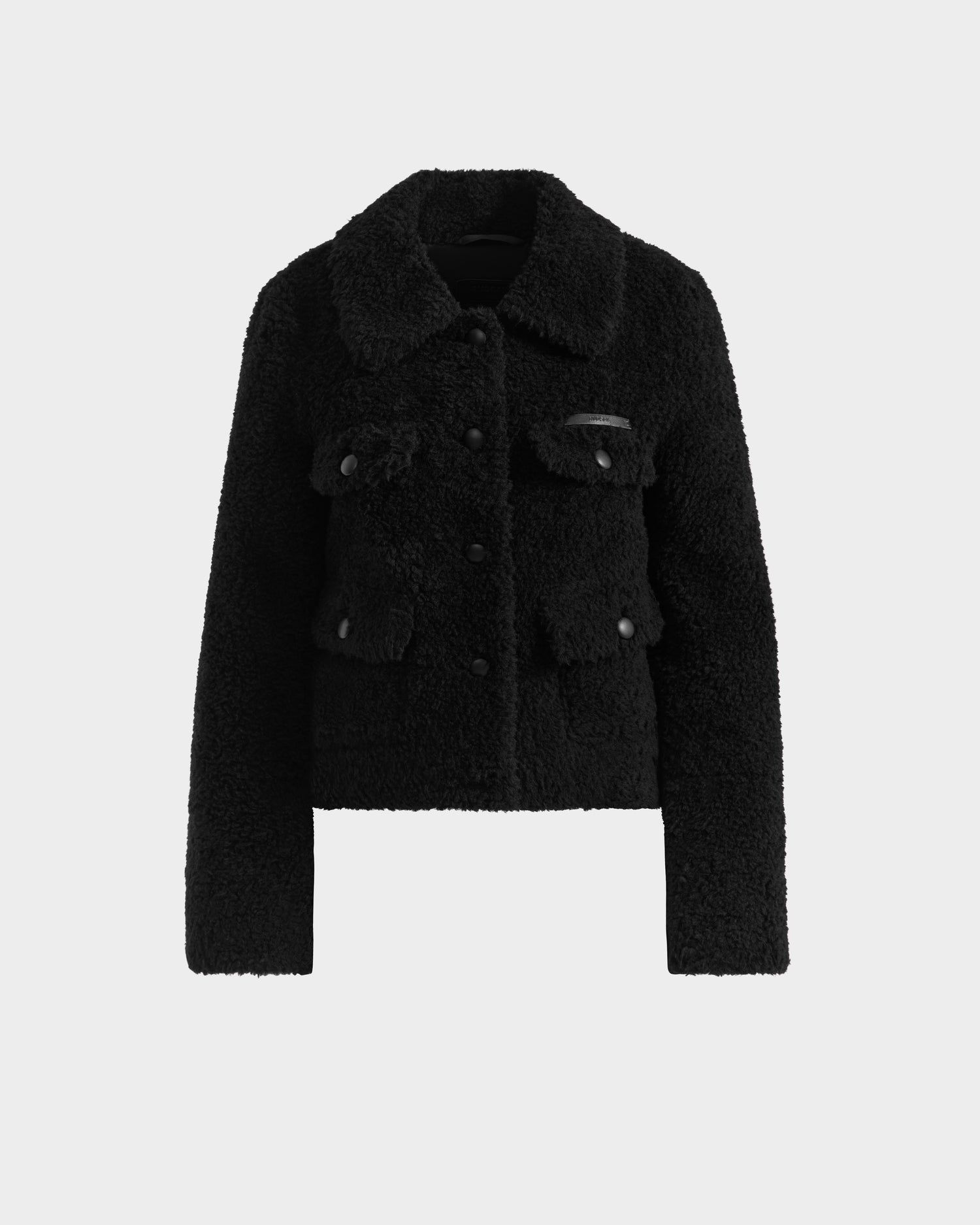The Rudsak BLAIR - 8125513 Black is a women’s cropped teddy jacket with long sleeves, a collar, front buttons, and four flap pockets, shown against a plain white background.