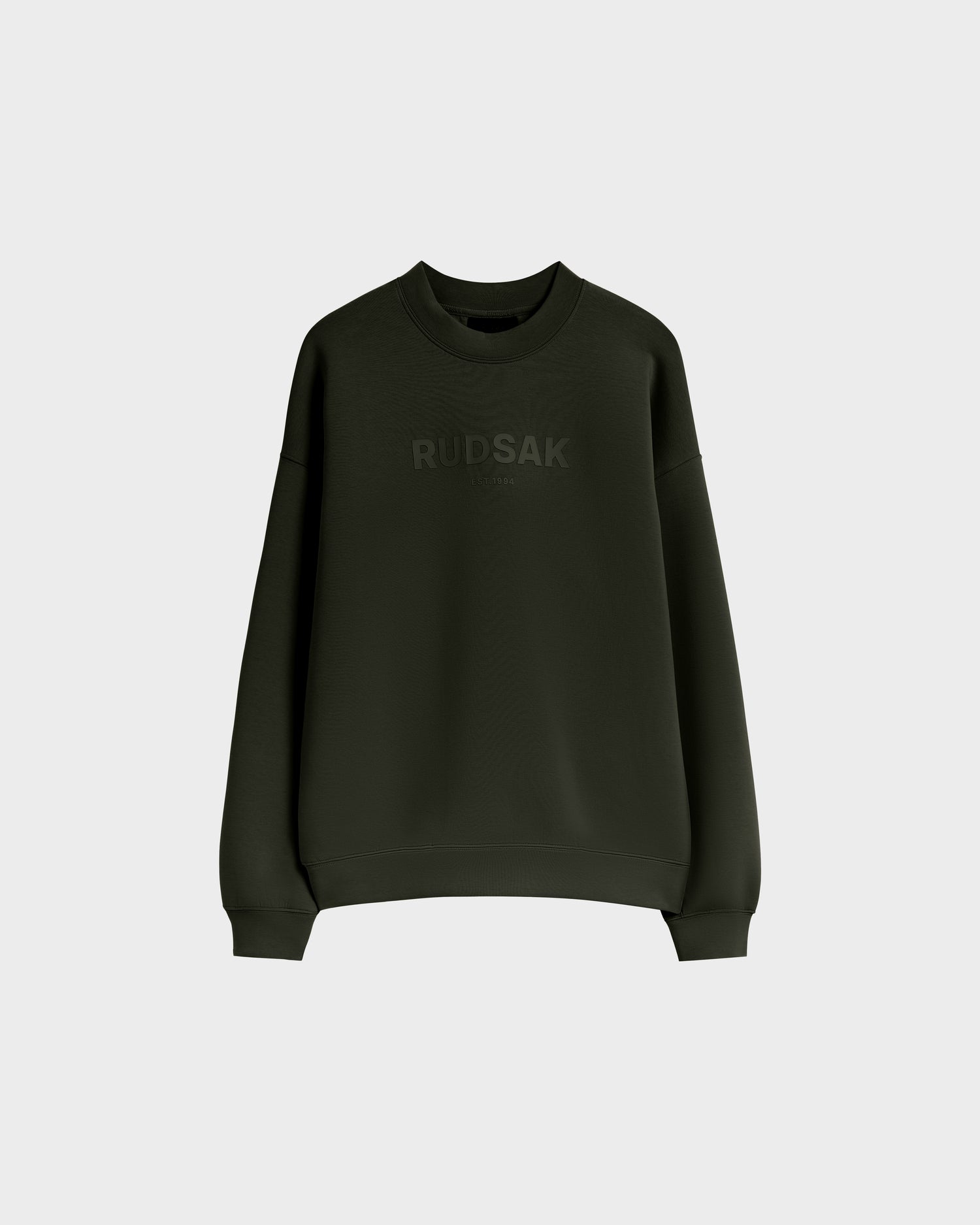 The BRYN - 9524007 Dark Olive W by Rudsak is a dark green cotton crewneck sweatshirt with long sleeves and a subtle chest logo, designed in a timeless, genderless style and shown on a plain light grey background.