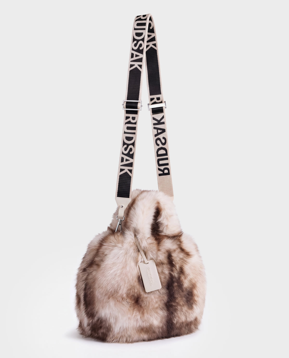 Rudsak CABAS - 8325545 Mix Vanilla fluffy, multi-toned faux fur bucket bag featuring a beige and black branded fabric shoulder strap, perfect as a winter statement accessory.