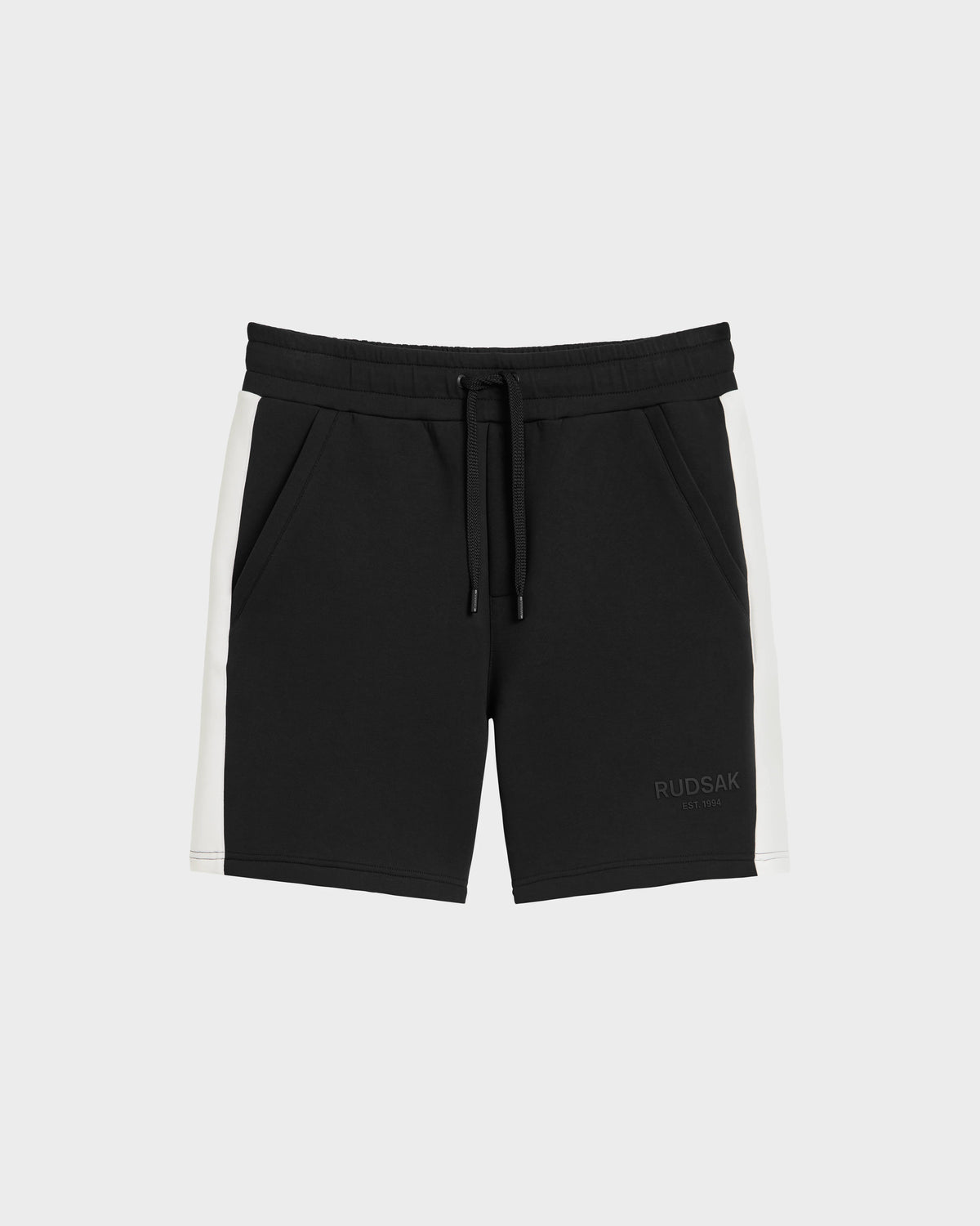 The Rudsak CAMDEN - 6525028 Black men’s jogger shorts feature white side panels, an elastic waistband, drawstring, side pockets, soft cotton-blend fabric, and a subtle RUDSAK logo on the front left leg. Perfect for your casual wardrobe.