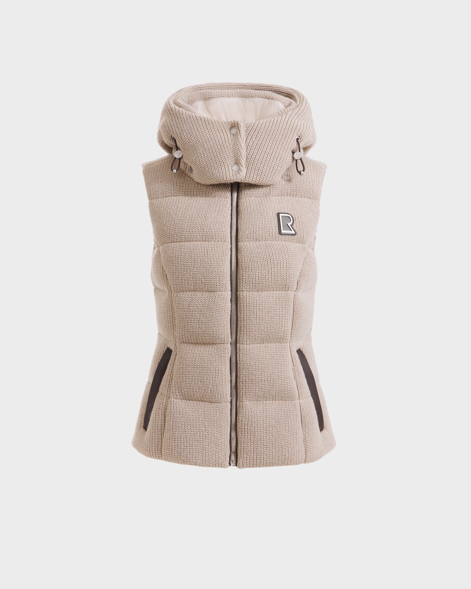 Rudsak CASSIDY - 8125622 Vanilla quilted sleeveless travel vest in beige with a high padded collar, lightweight warmth, two front zippered pockets, front zipper closure, and a small R patch on the left chest. Shown on a white background.