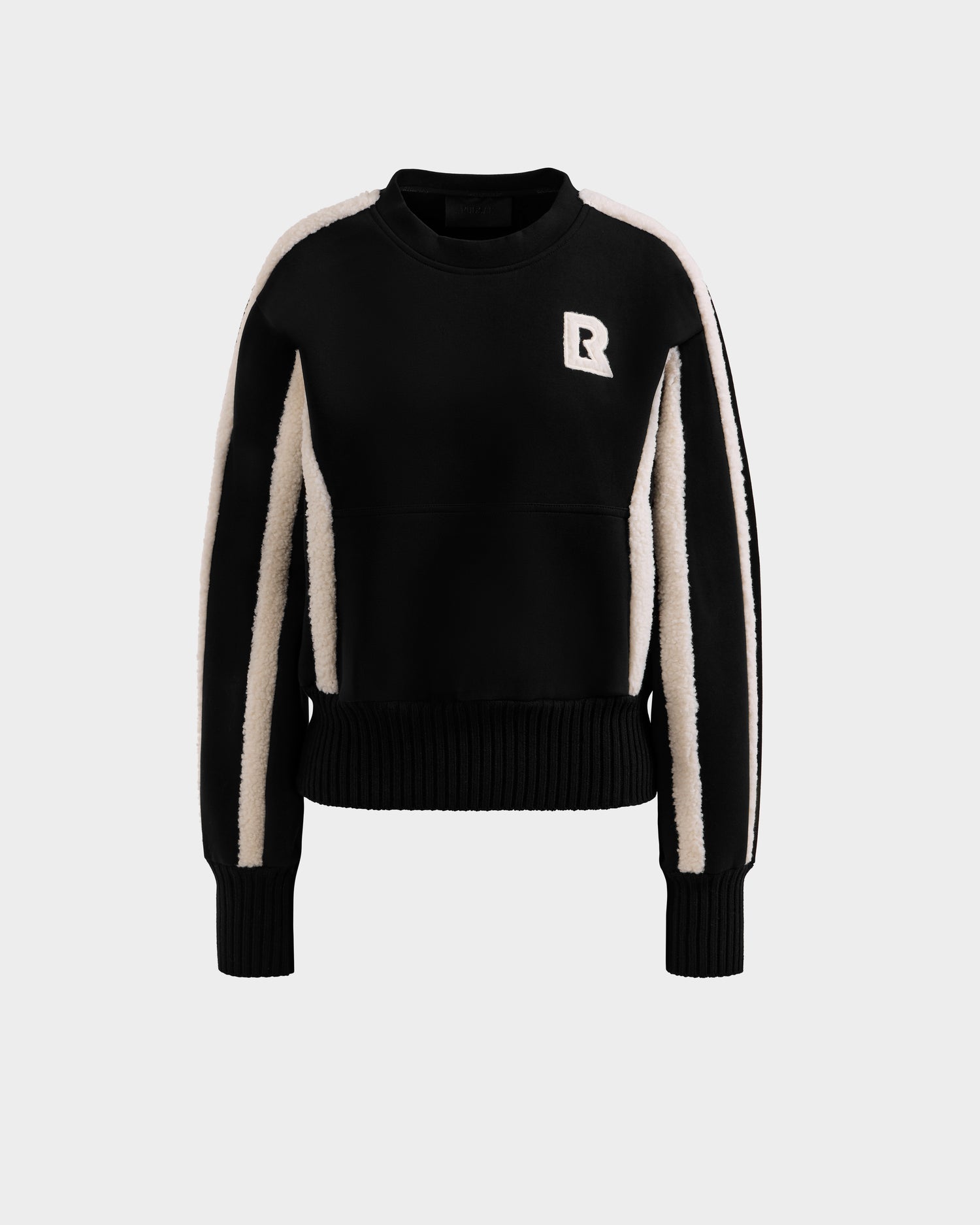 The Rudsak CHANA - 8525656 Black women’s crew neck sweatshirt features white vertical sleeve stripes and a white R chest patch, perfect for an après-ski look and shown against a plain light gray background.