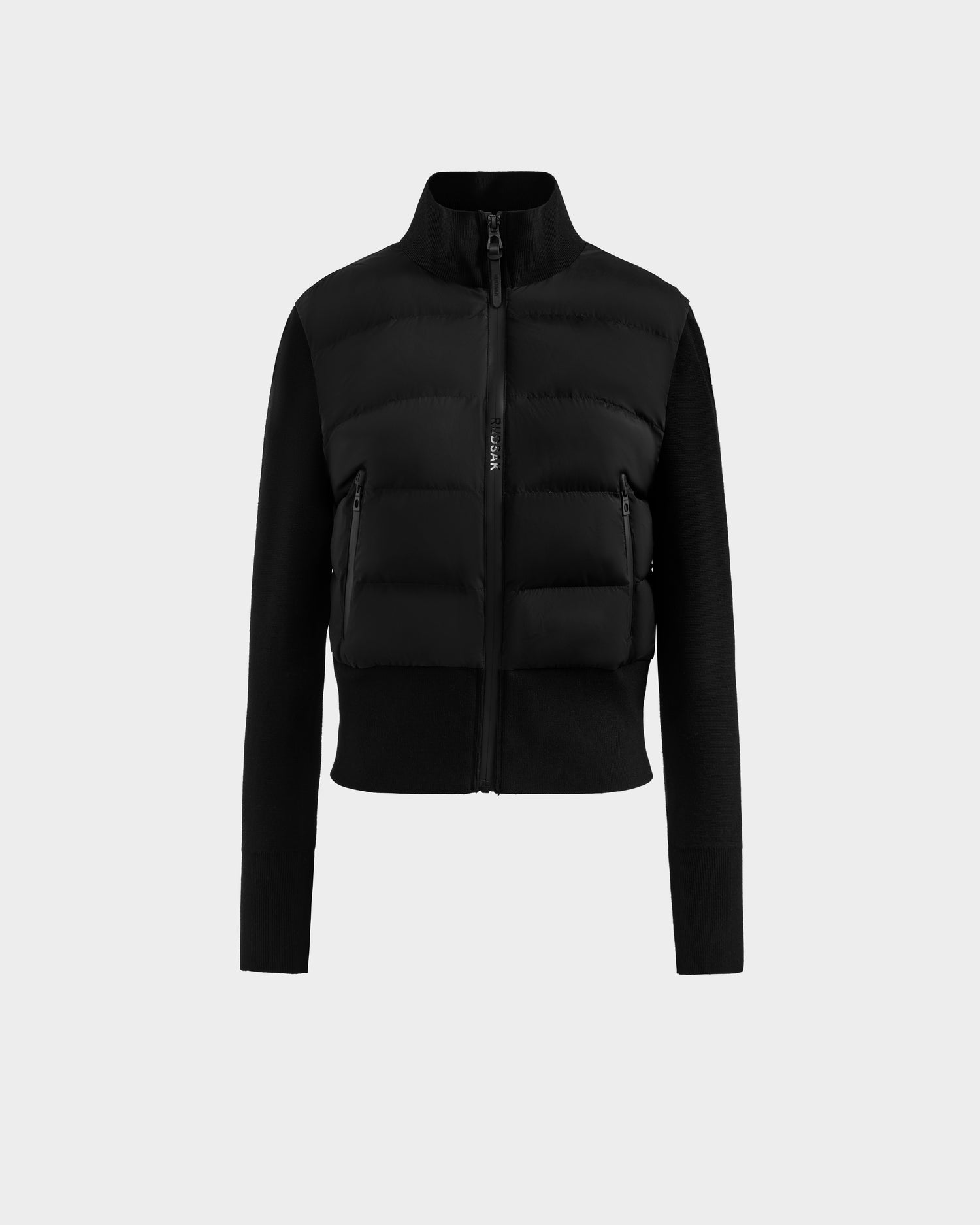 The Rudsak CLAREMONT - 8125502 Black is a women’s hybrid down jacket featuring a high collar, quilted RDS-certified down front, smooth fabric sleeves, and two front zippered pockets for style, comfort, and lightweight warmth.