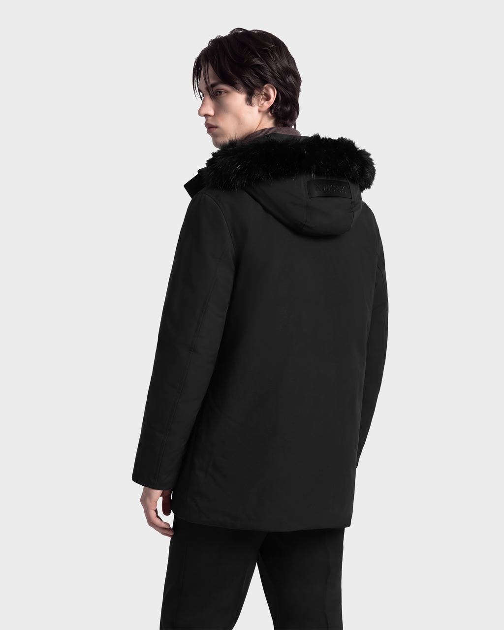 A man wearing an EDWARD - 6126501 Black winter parka with a faux fur-trimmed hood.