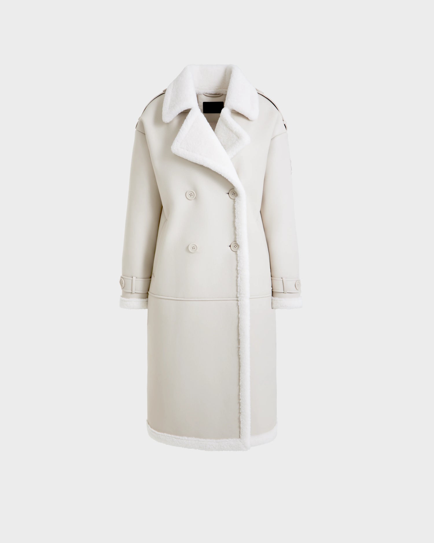 The DARCY - L125539 Vanilla by Rudsak is a long, double-breasted ivory vegan leather overcoat featuring a wide collar and white faux shearling trim on the collar, lapel, cuffs, and hem, displayed against a plain white background.