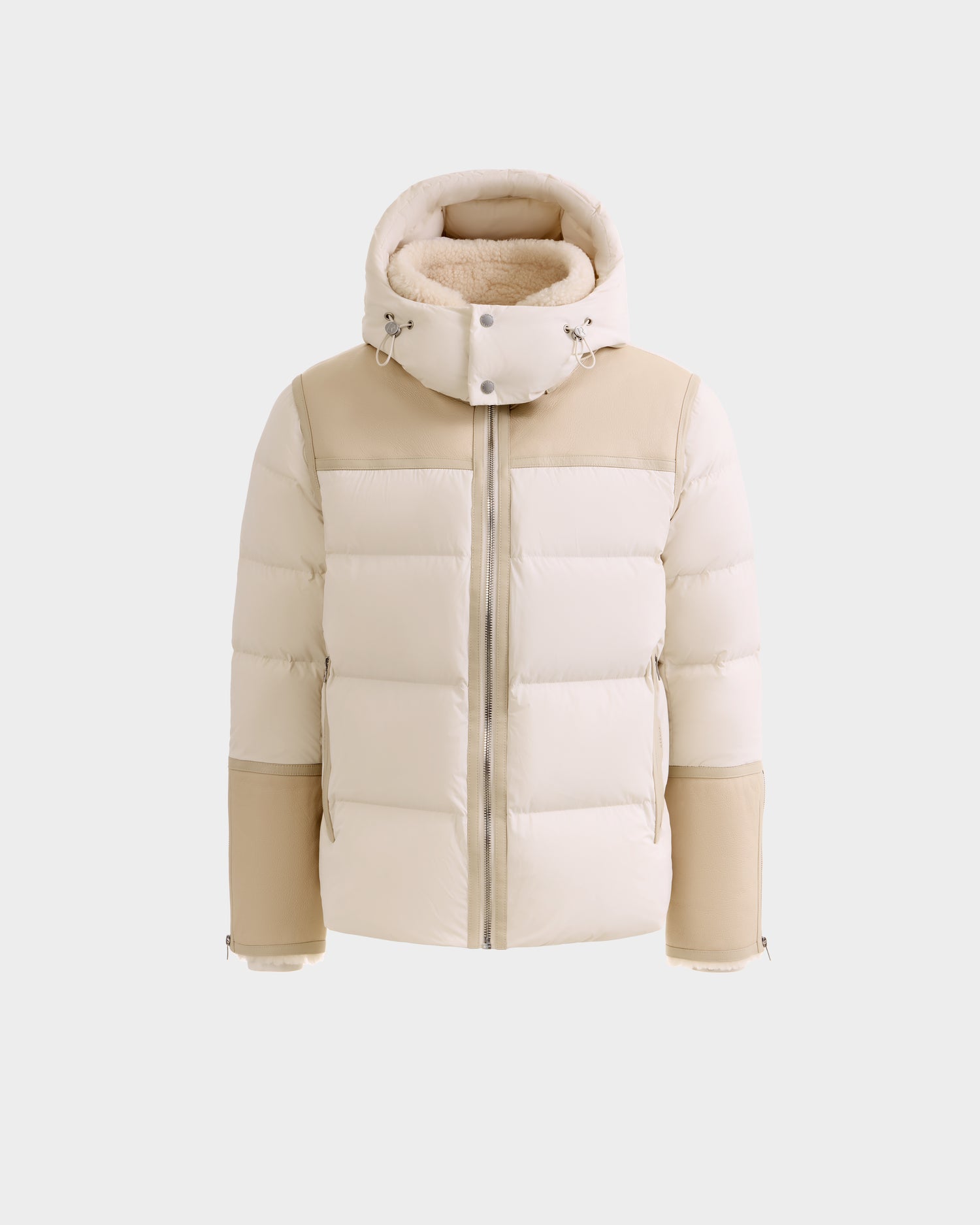 The Rudsak DAVID - M125508 Vanilla is a men’s beige and off-white shearling down puffer jacket with a hood, front zipper, and tan panels on the shoulders and cuffs, shown against a plain white background.