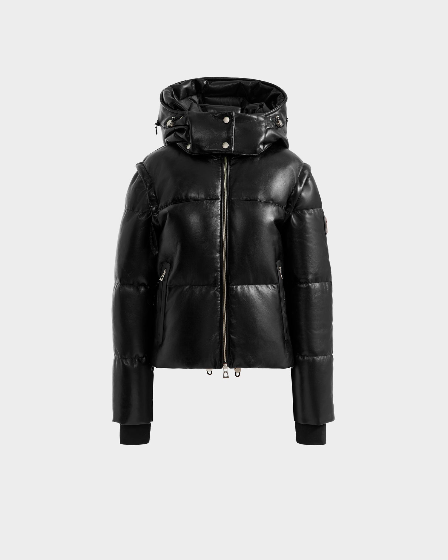 The DELILAH PX - L125537 Black by Rudsak, a women’s black vegan-leather puffer jacket with a shiny finish, front zipper closure, high collar, and ribbed cuffs, is displayed on a plain light gray background.