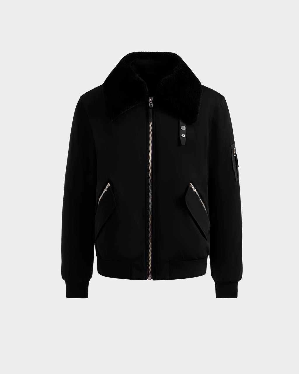 The DYLAN - 6125593 Black men's aviator bomber jacket by Rudsak features a large faux fur collar, front zipper closure, zippered side pockets, and a zippered sleeve pocket, shown on a light gray background—modern outerwear.