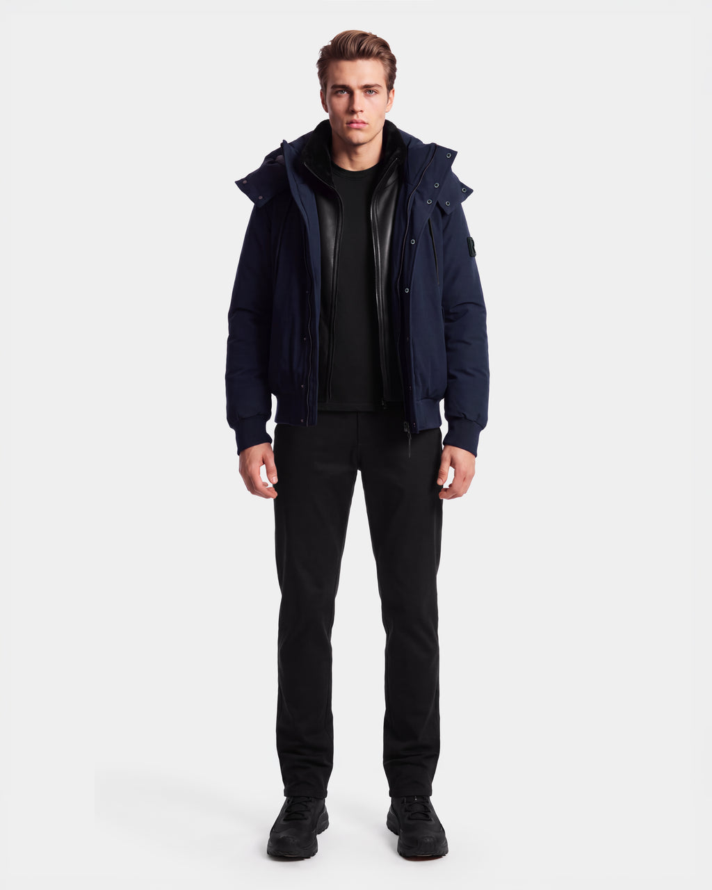 A man stands facing forward against a plain white background, wearing the Rudsak WILL - 6126561 Navy bomber jacket over a black shirt, paired with black pants and black shoes.