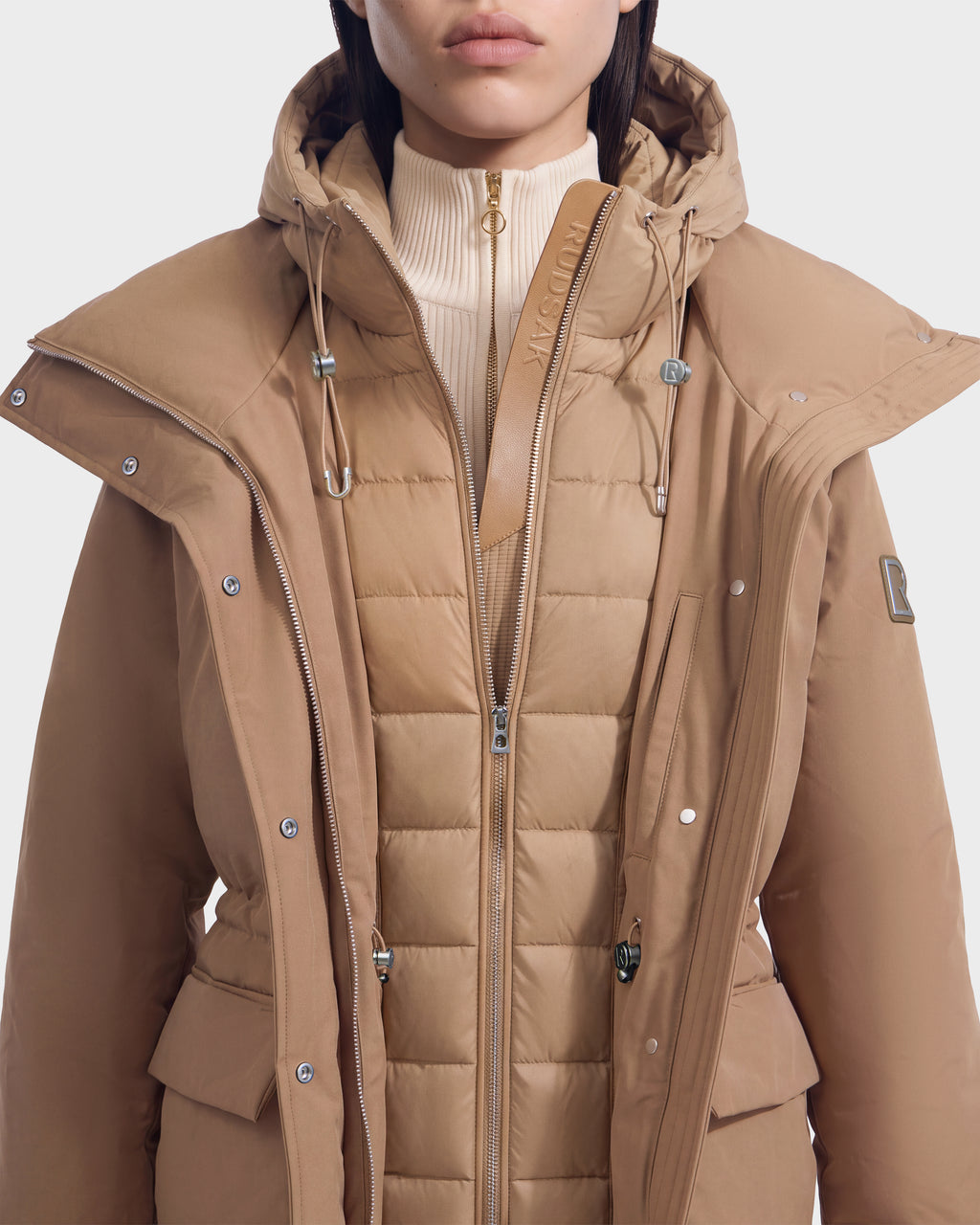 A Rudsak BHIMA - 8126515 Camel tan hooded puffer jacket with an inner quilted vest layer and a high-neck knit collar.