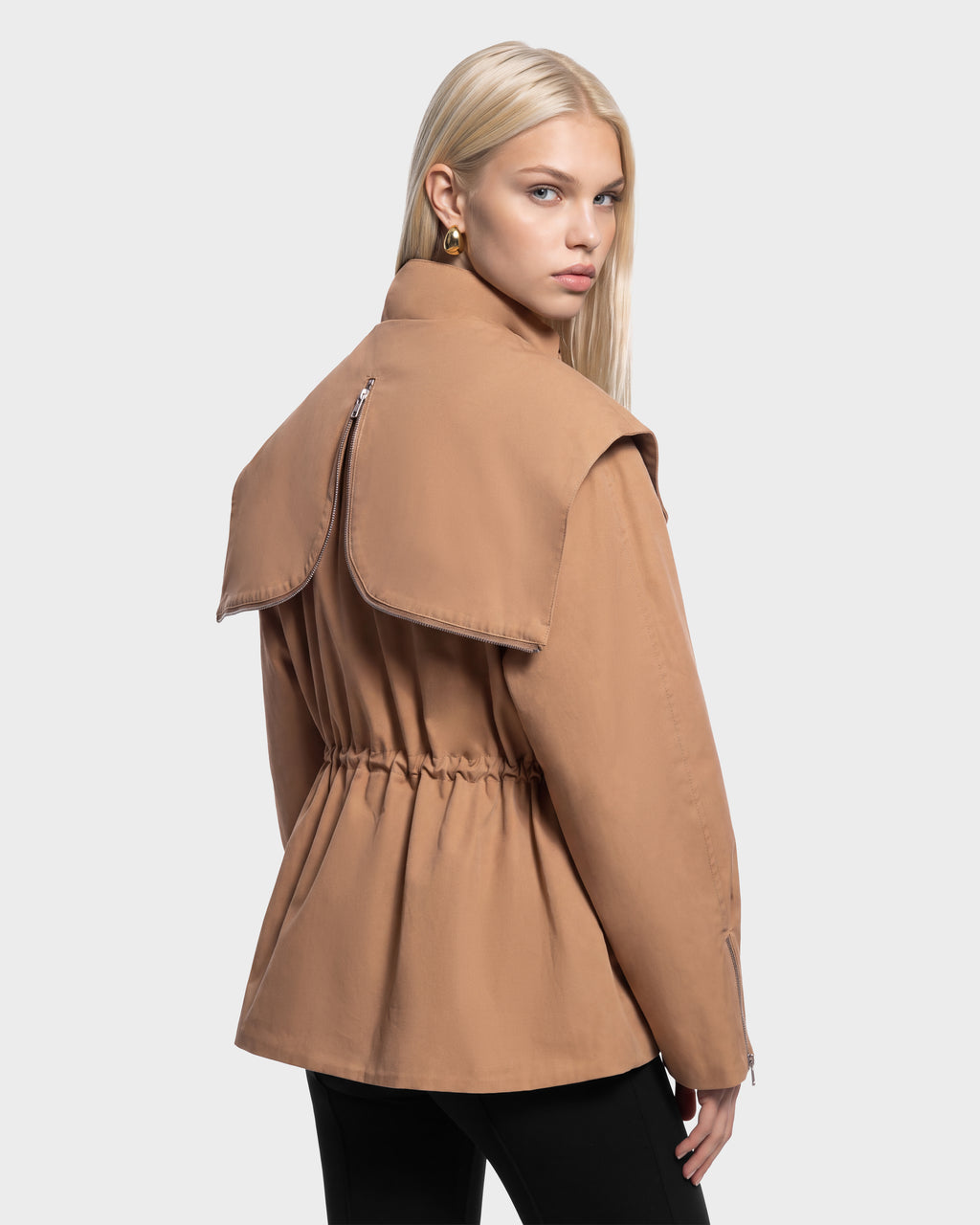 A model wearing a camel-colored ROSALINDA - 8126523 Camel jacket with a large, zipper-detailed back collar and a cinched waist.