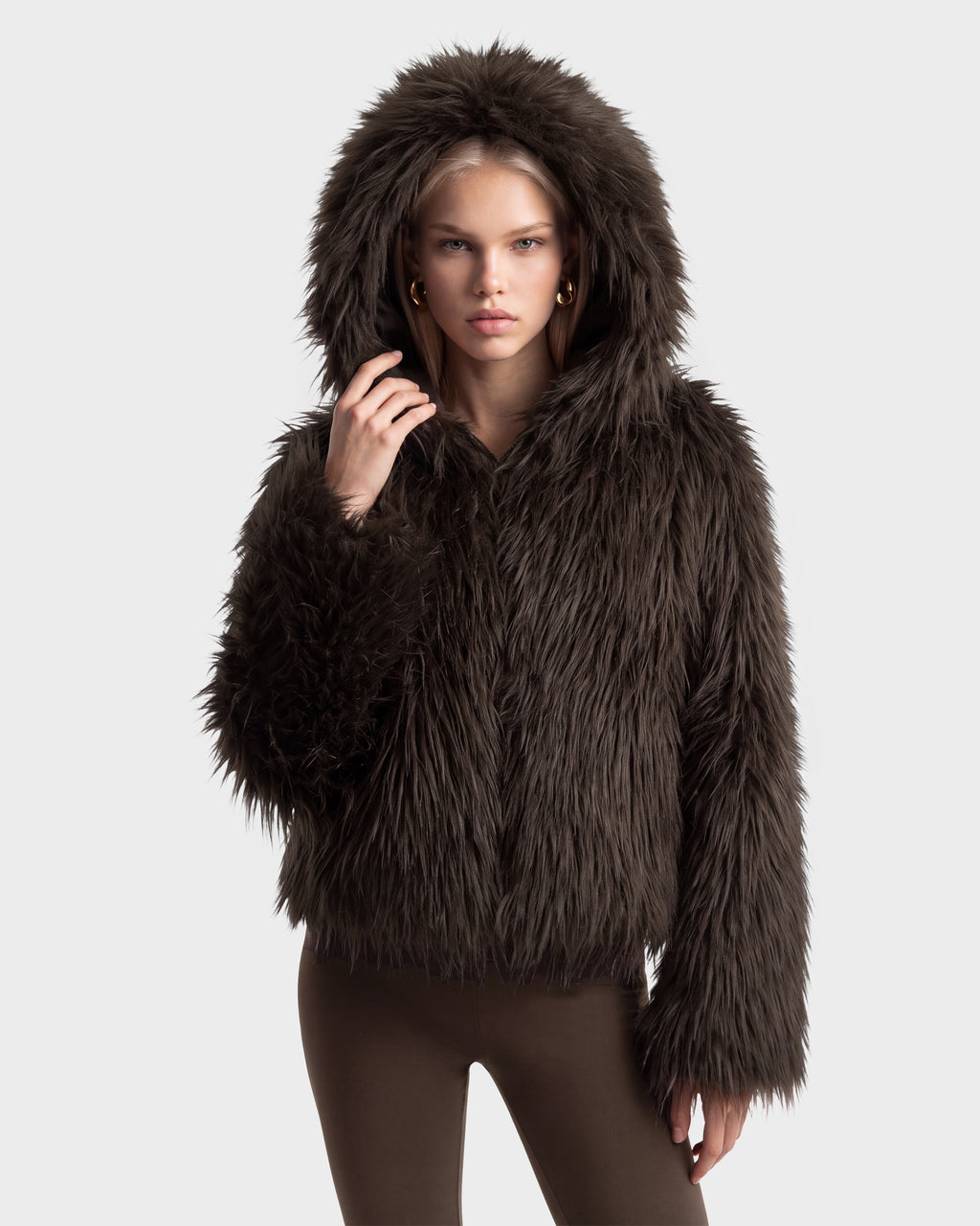 A person wears an ELLISON - 8525678 Espresso dark brown faux fur hoodie with an oversized hood pulled up.