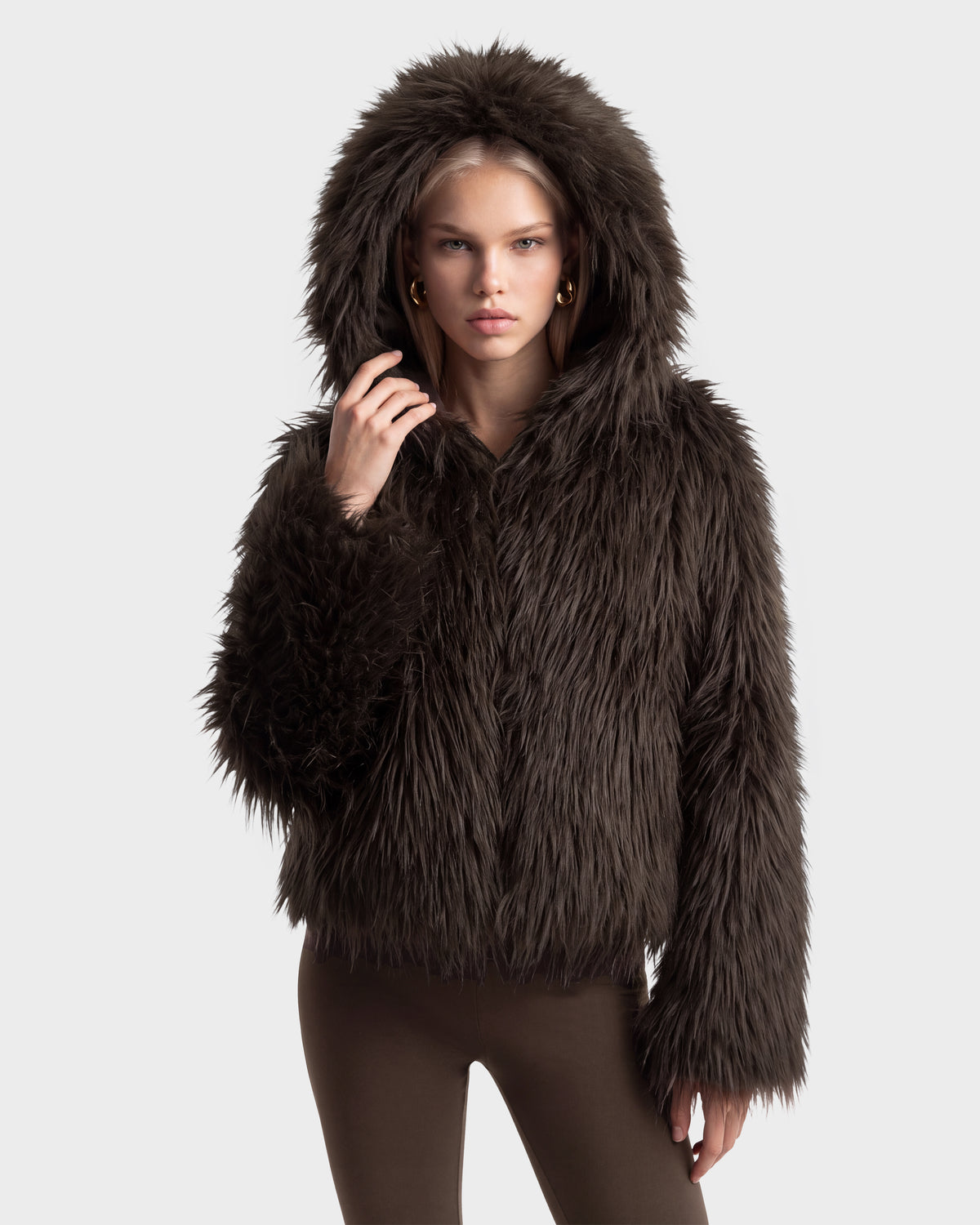 A person wears an ELLISON - 8525678 Espresso dark brown faux fur hoodie with an oversized hood pulled up.
