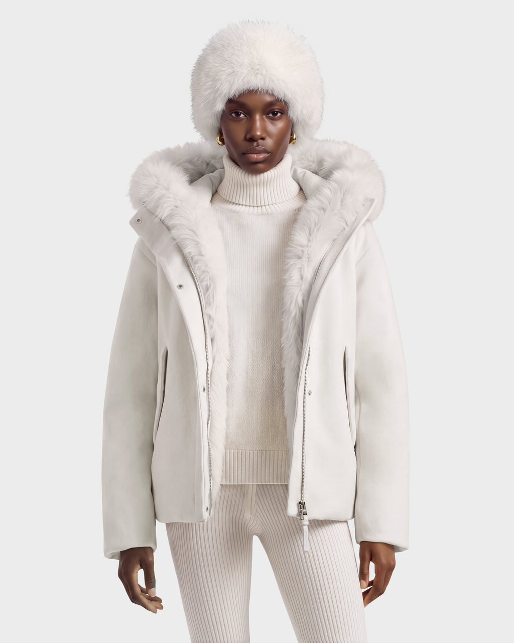 A person wearing a HAZEL - 8126981 Vanilla white duck down insulated hooded jacket with faux-fur trim and a matching fur hat.