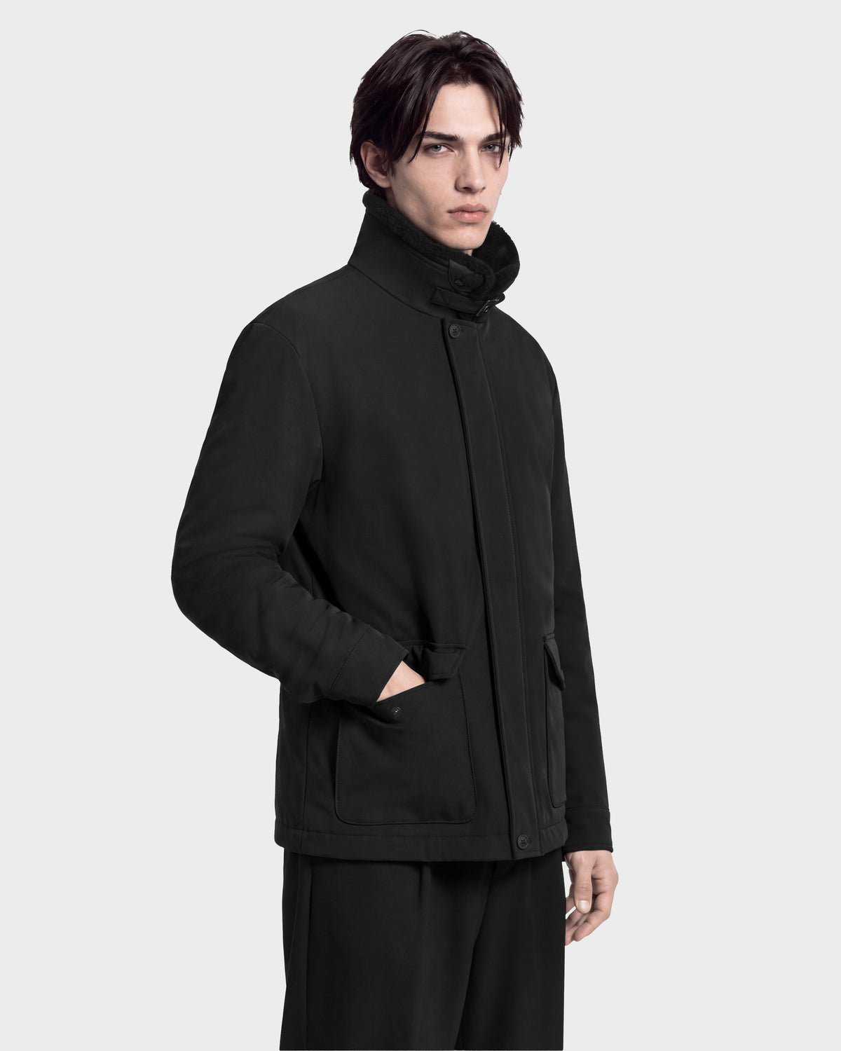 A man wearing a black ANTOINE - 6126506 utility jacket with a high collar and front pockets.