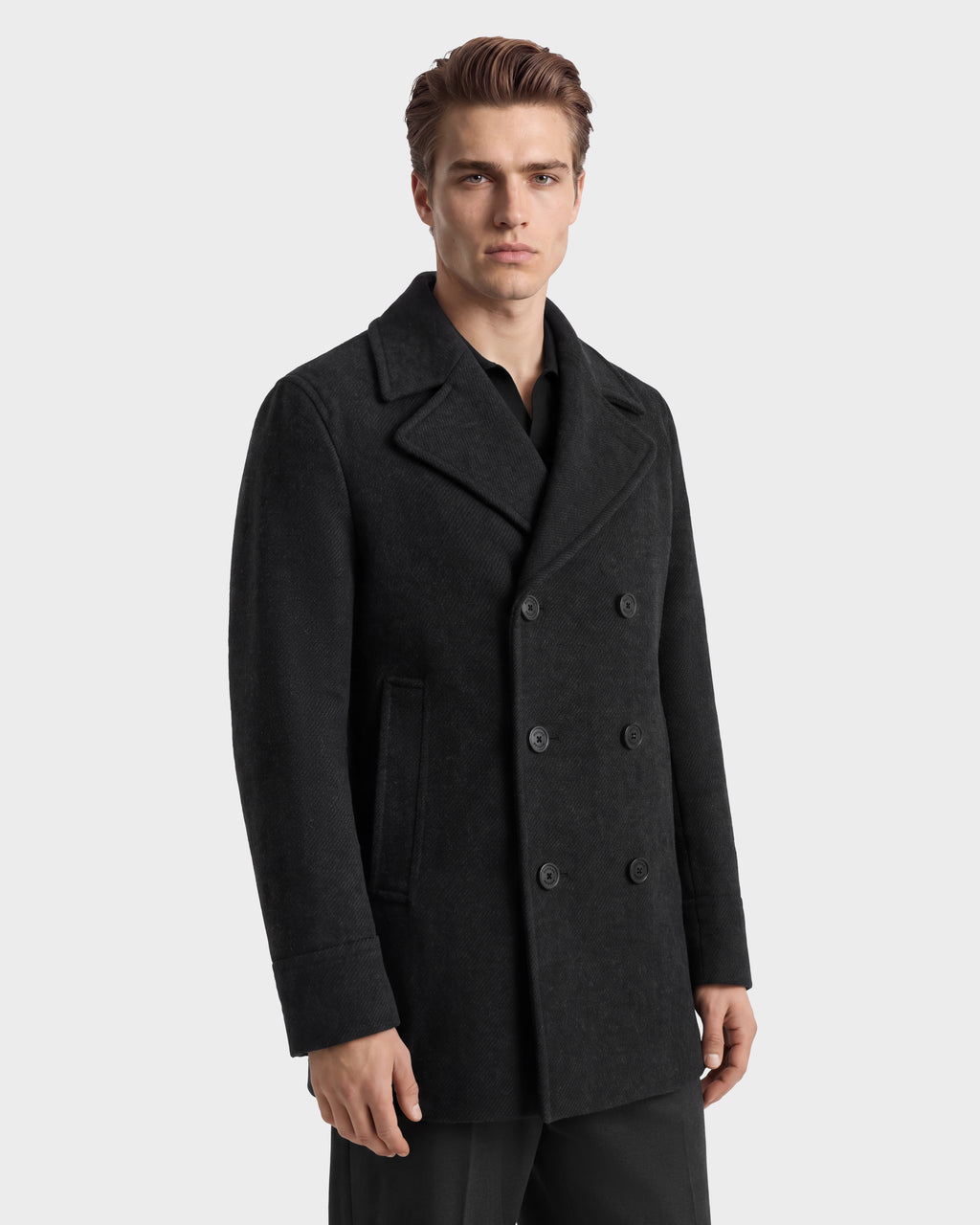 A man wears a charcoal Rudsak LUCIEN - 6126508 double-breasted wool-blend pea coat over a black shirt.