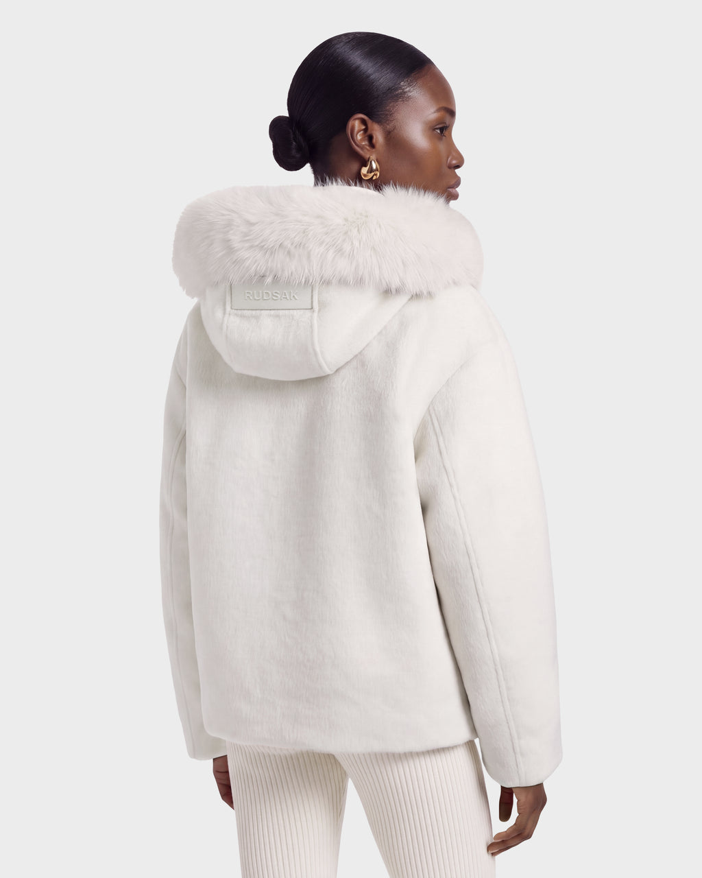 A person wearing a HAZEL - 8126981 Vanilla white hooded jacket with a faux-fur trim.