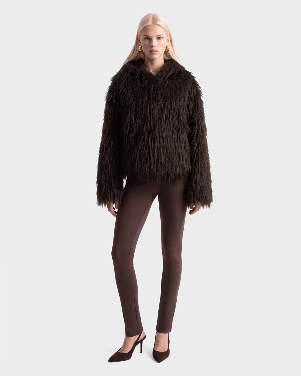 A model wearing a RUDSAK ELLISON - 8525678 Espresso faux fur hoodie with an oversized hood, matching leggings, and heeled pumps.