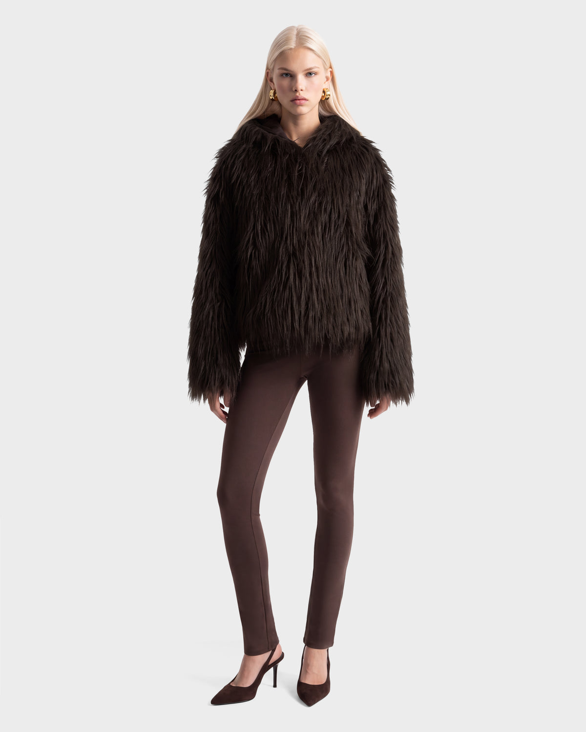 A model wearing a RUDSAK ELLISON - 8525678 Espresso faux fur hoodie with an oversized hood, matching leggings, and heeled pumps.