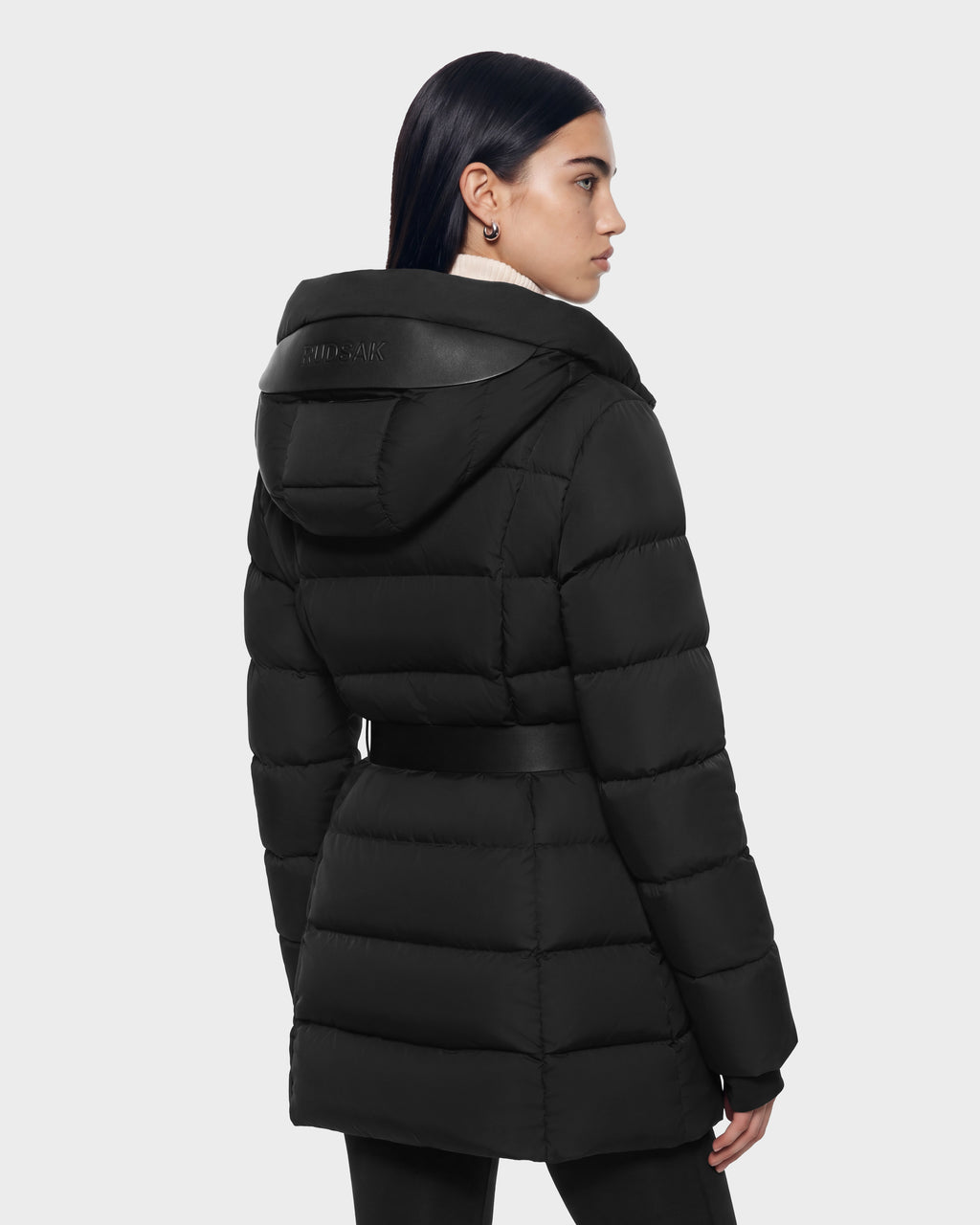 A person wears a black RUDSAK TAYLOR M - 8125965 belted, hooded winter jacket.