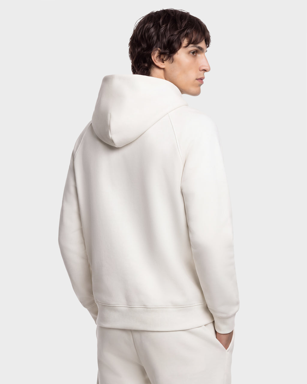 Back view of a person wearing a plain cream-colored BRIAR - 9525001 Vanilla M RUDSAK unisex hoodie.