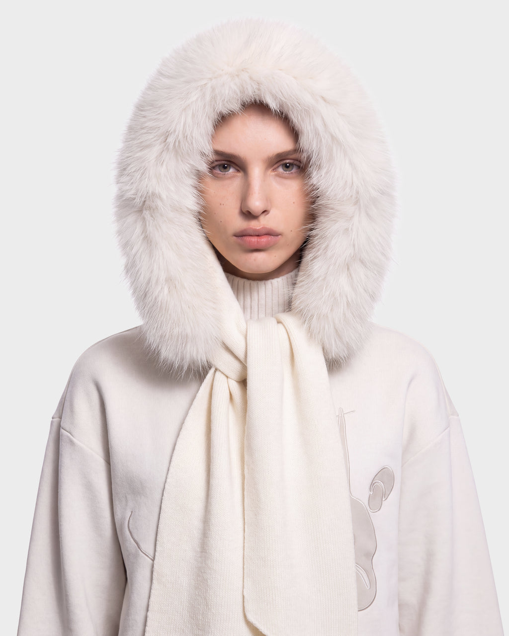 A person wearing the Rudsak KARYMA - 8426507 Vanilla fluffy white hood and matching scarf over a high-neck light sweater, looking straight ahead with a neutral expression, on a plain light background.