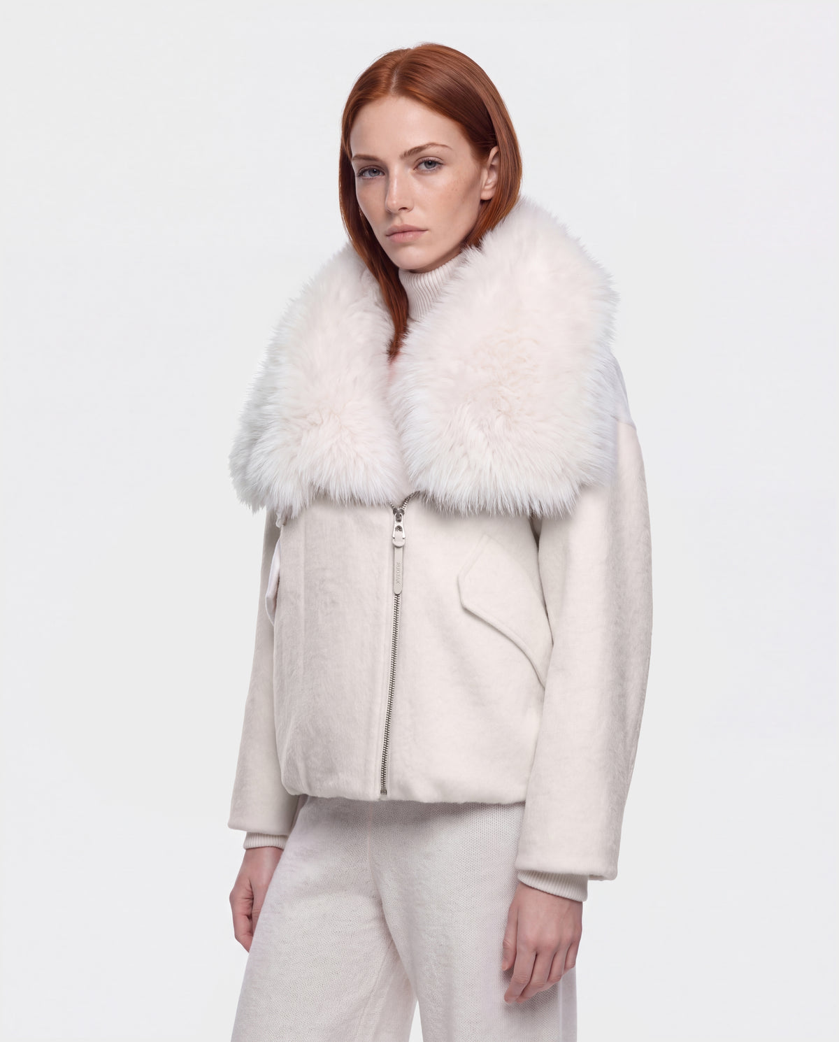 A woman wears a vanilla-colored ZARIA - 8126999 winter puffer with a large faux-fur collar.