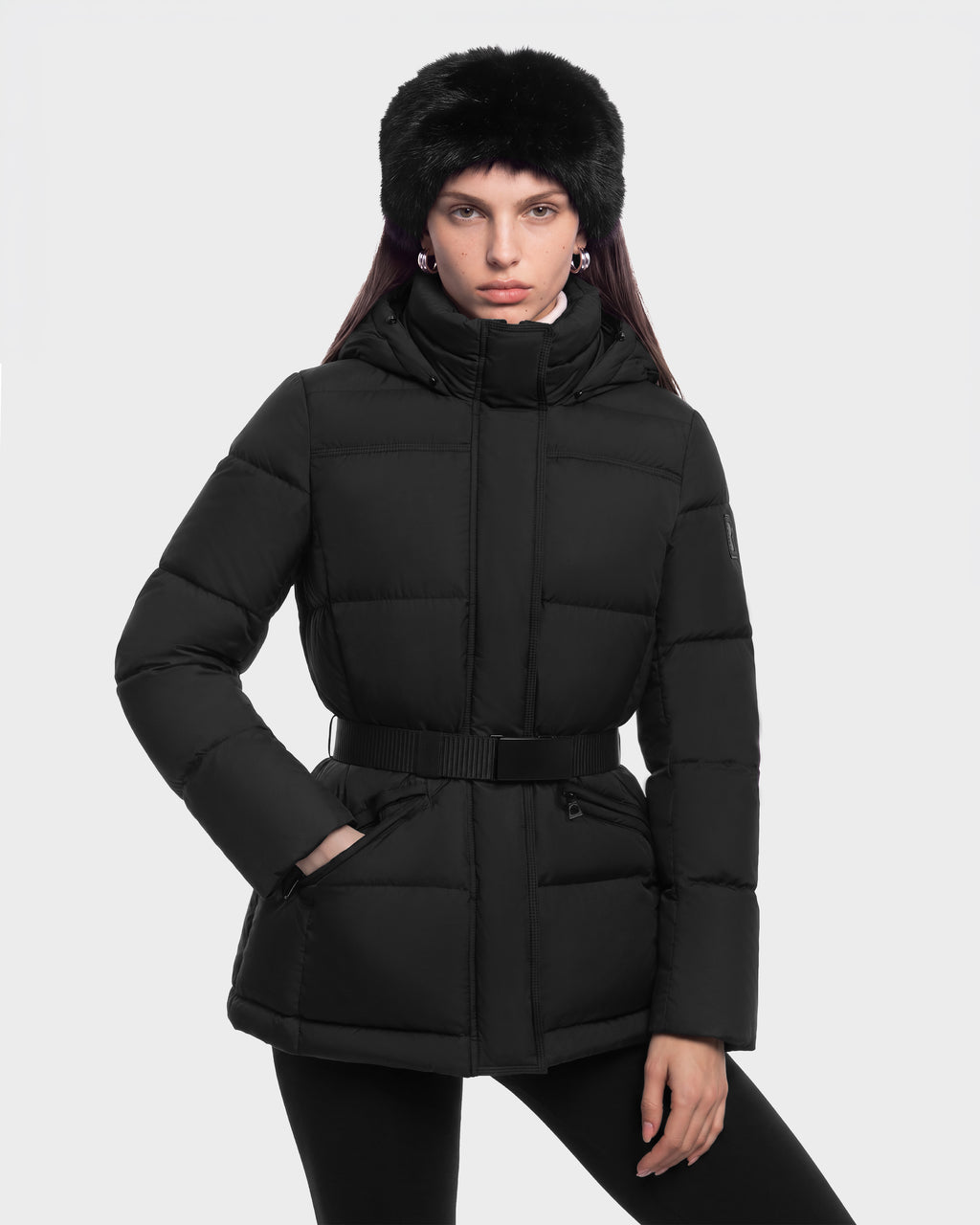 A person wearing a black GRACE FF - 8126535 Black hooded puffer jacket with a belted waist and a black faux fur hat.