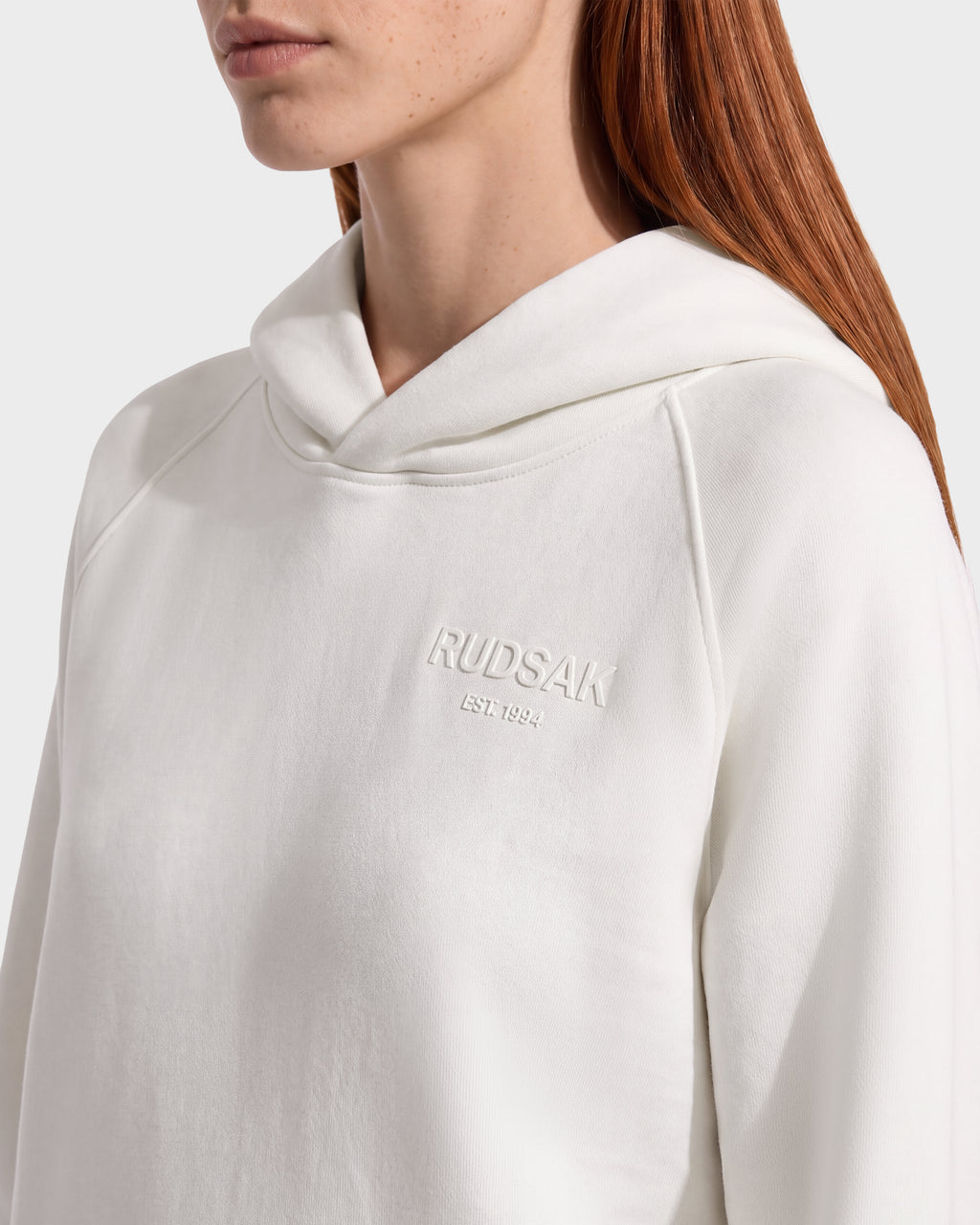 A white unisex RUDSAK BRIAR - 9525001 Vanilla W hooded sweatshirt featuring the embossed text EST. 1994 on the chest.
