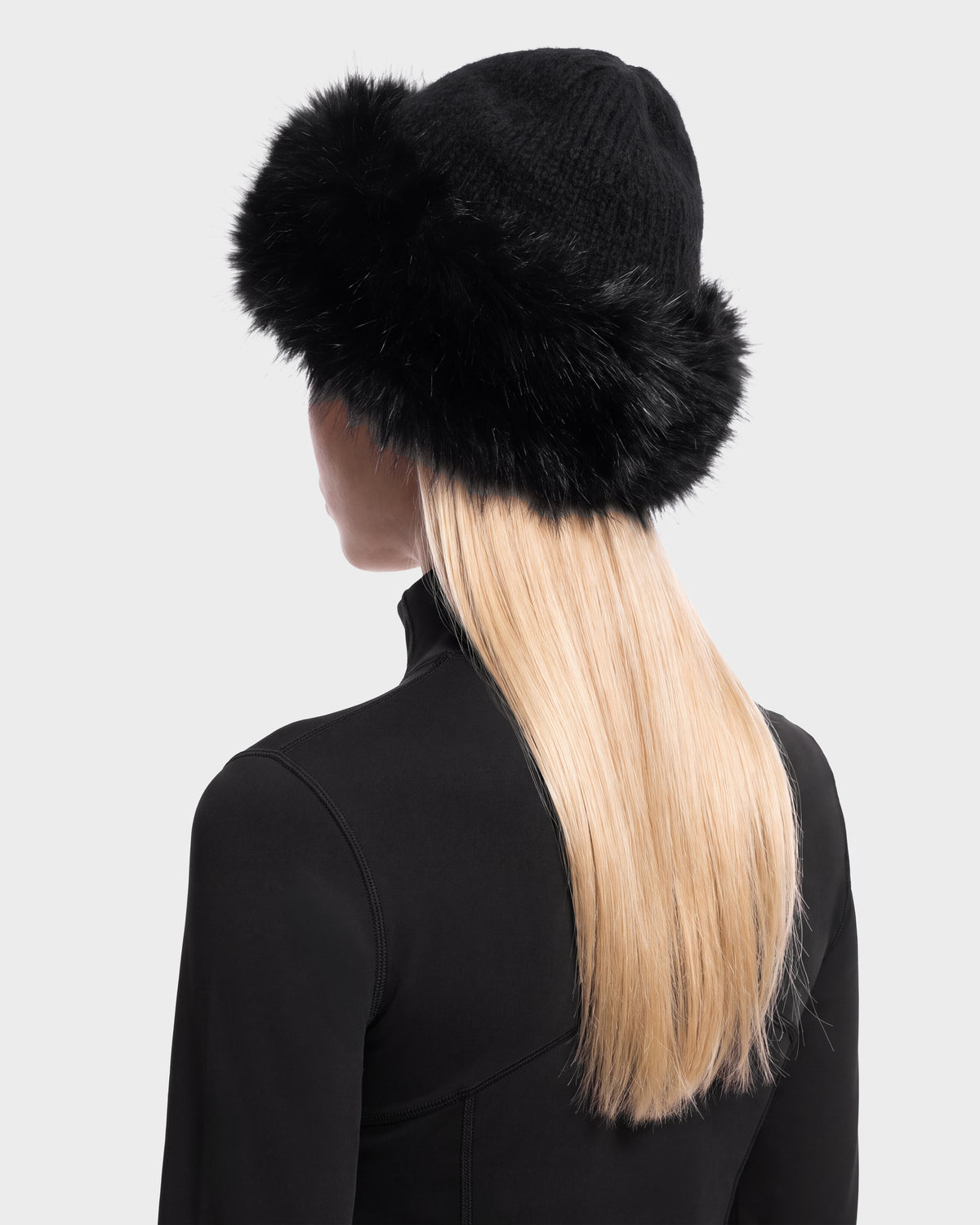 A person viewed from the back wearing a black LORETTA W - 8426510 RUDSAK knit hat with a wide faux fur brim.