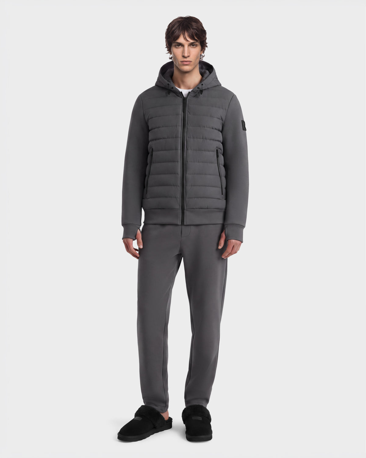 A person wearing a grey DEE MAT - 6124028 RUDSAK lightweight hybrid down jacket with matching sweatpants and black slip-on shoes.