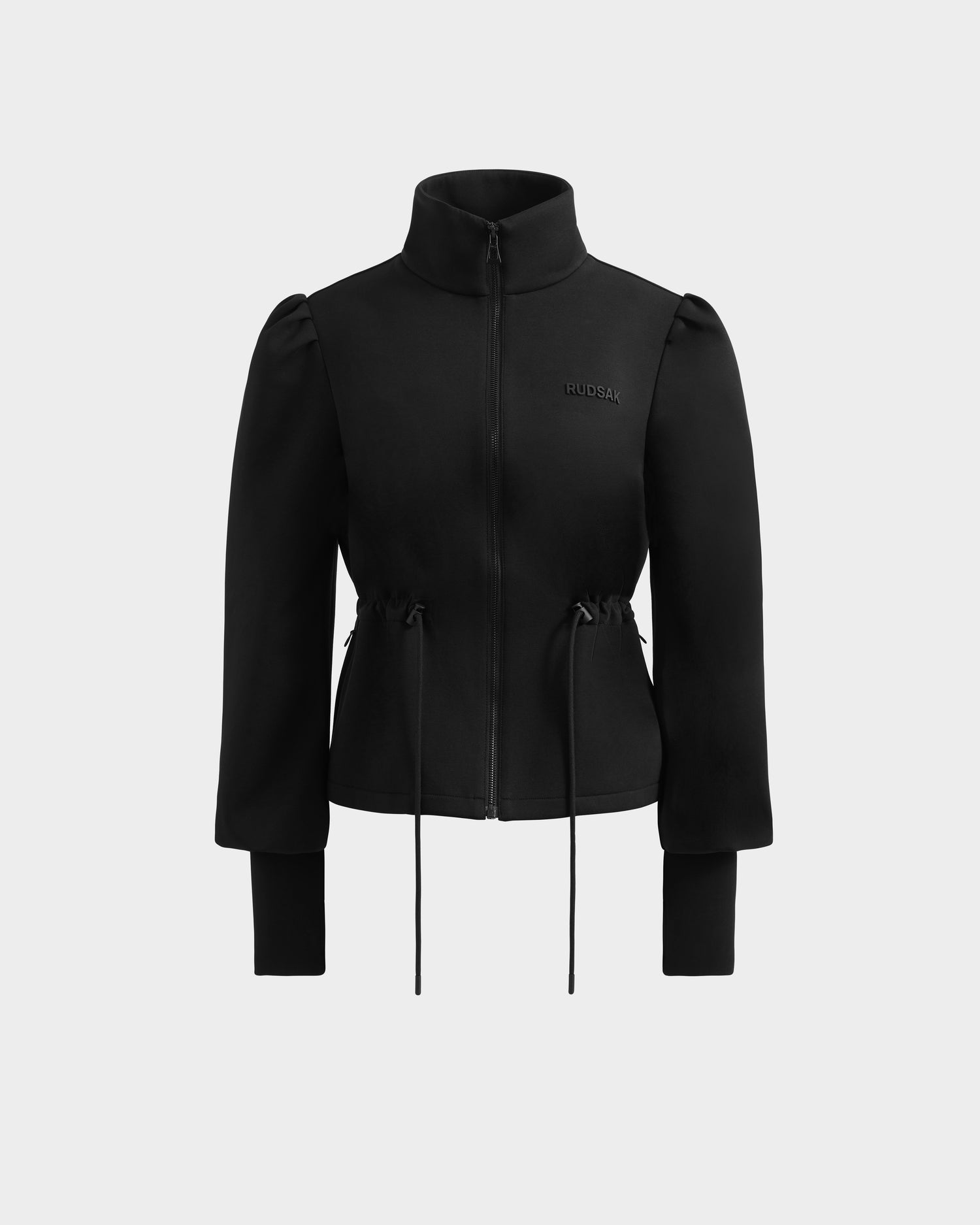 The Rudsak ELODIE - 8526039 Black is a black zip-up sweater jacket with long sleeves, high collar, adjustable drawstring waist, and subtle chest logo—an ideal lightweight sports-casual layer shown on a light gray background.