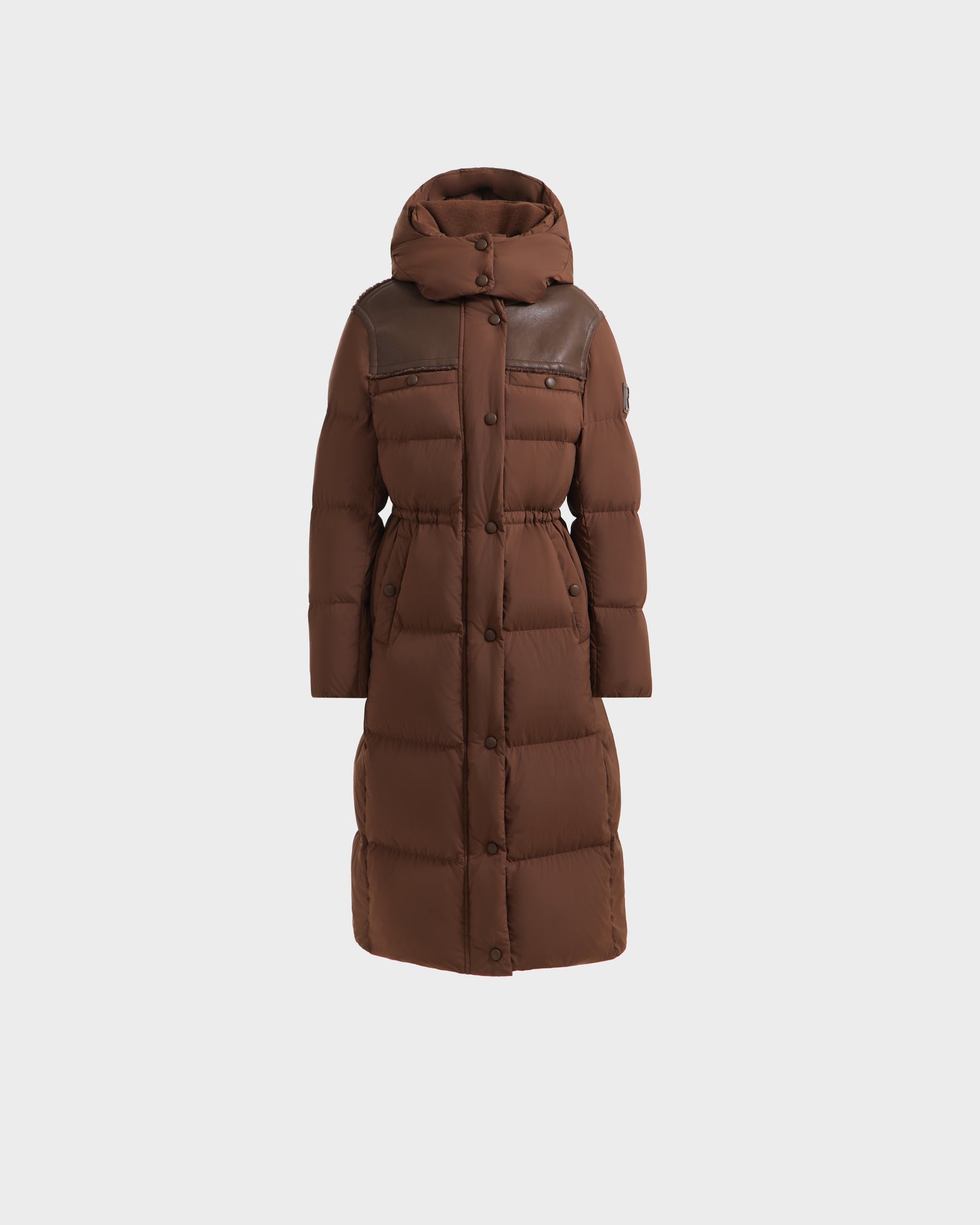 The Rudsak EMBER M-L - L125543 Mocha is a women’s long down puffer with RDS-certified down, a hood, button and zipper closures, faux vegan leather chest accents, and a fitted waist, shown on a plain white background.