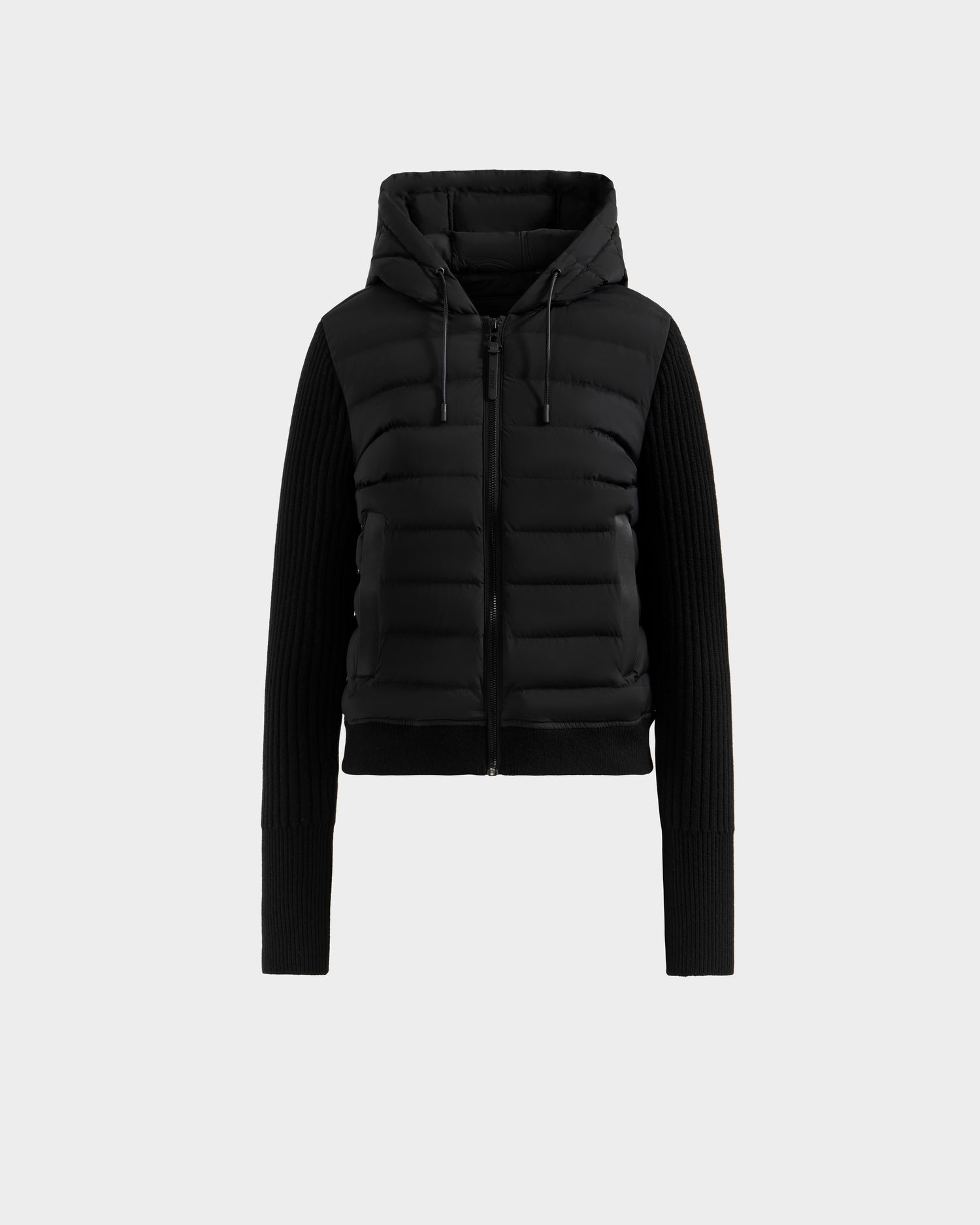 The Rudsak EMILY - L125515 Black is a women’s hooded down bomber with quilted panels, ribbed long sleeves, front zipper, and hood drawstrings, shown on a plain light gray background.