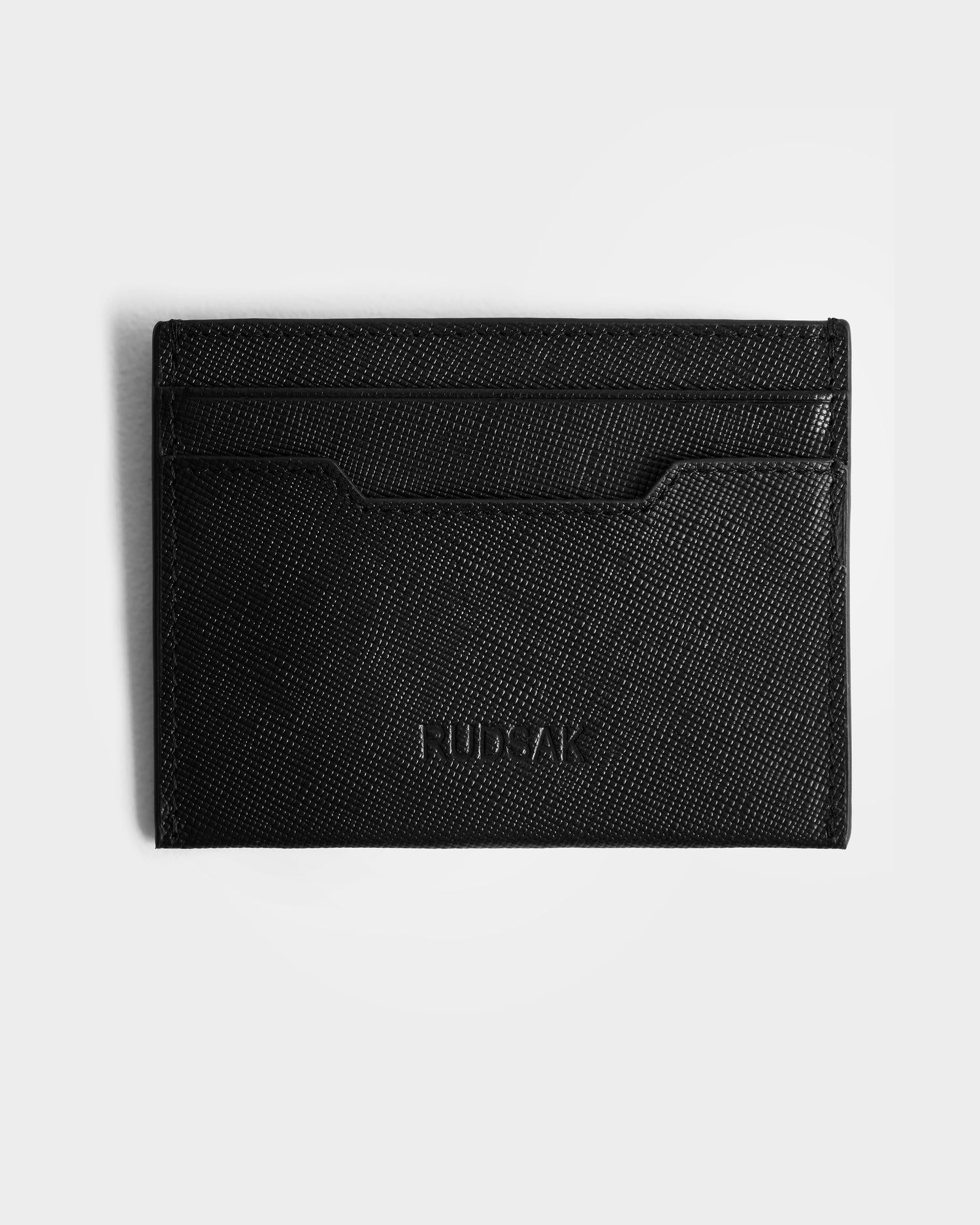The RYLIE - M424500 Black by Rudsak is a black textured leather card holder with multiple slots and an embossed logo on the front, shown on a white background—ideal for men’s box sets or as a stylish gift.