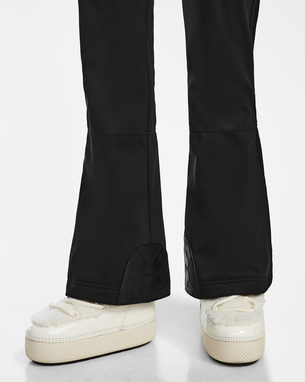 A person’s legs and feet wearing Rudsak CARMEN - 8124783 Black pants with faux shearling details and white shoes.