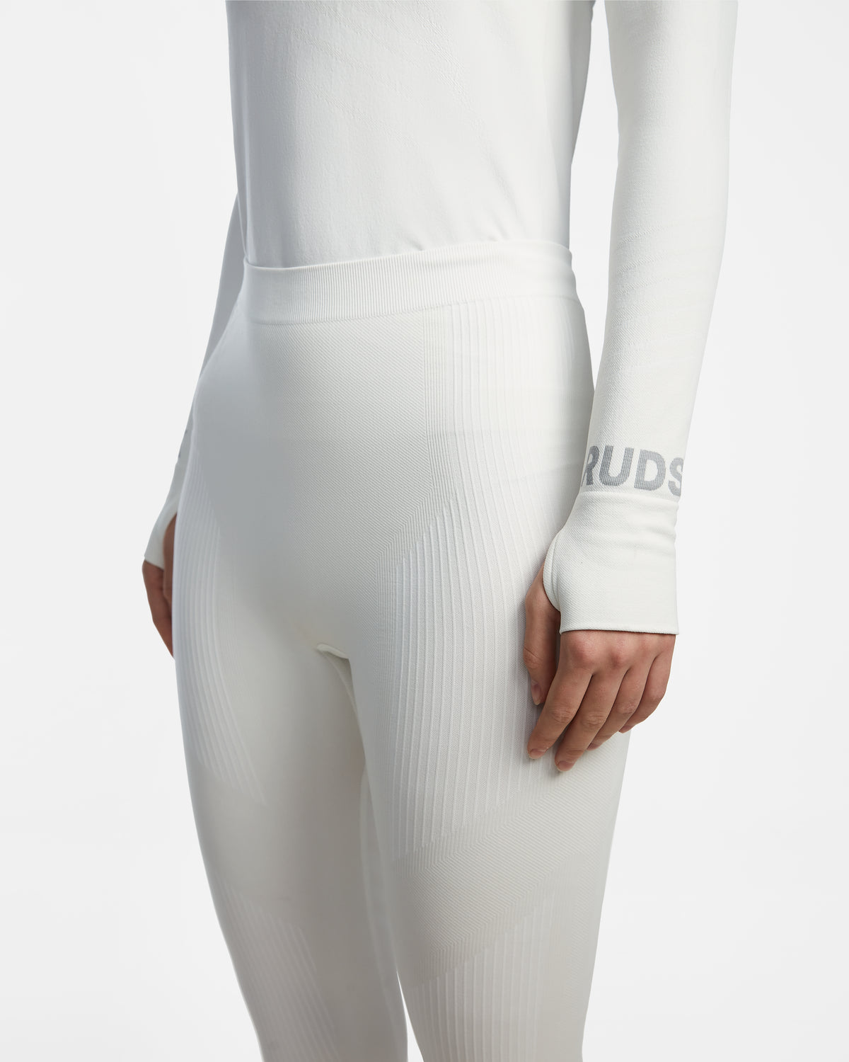 A model in the CARRIE - 8524619 Iceland by Rudsak: a fitted, long-sleeve white top and high-waisted stretch leggings, RUDSAK logo partly visible on the sleeve—ideal as a women’s thermal set or ski base layer.