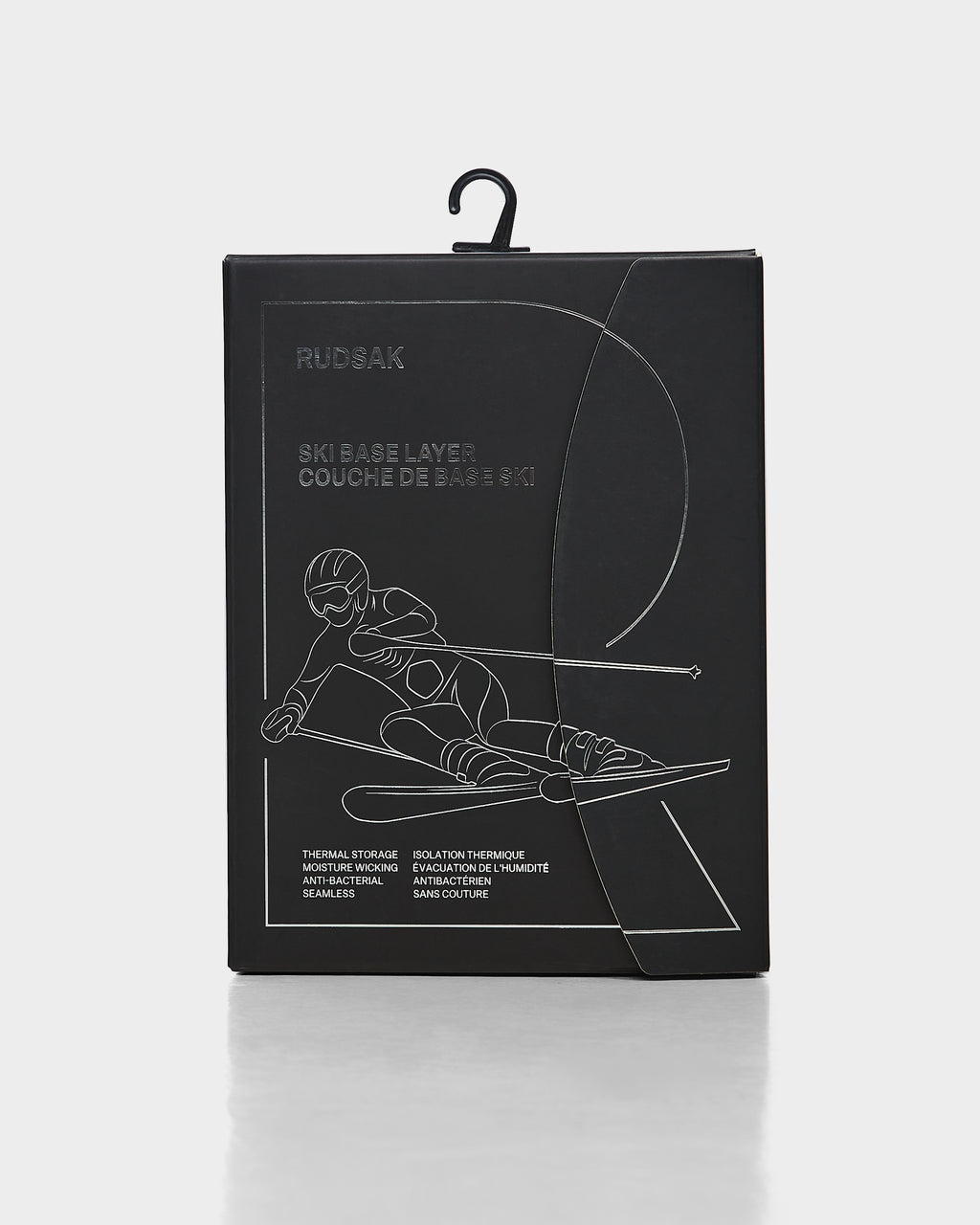 Black box with an outline of a downhill skier in motion. Text reads Rudsak and CARRIE - 8524619 Iceland, highlighting women’s thermal set and stretch leggings. Box features a handy hanging hook on top.