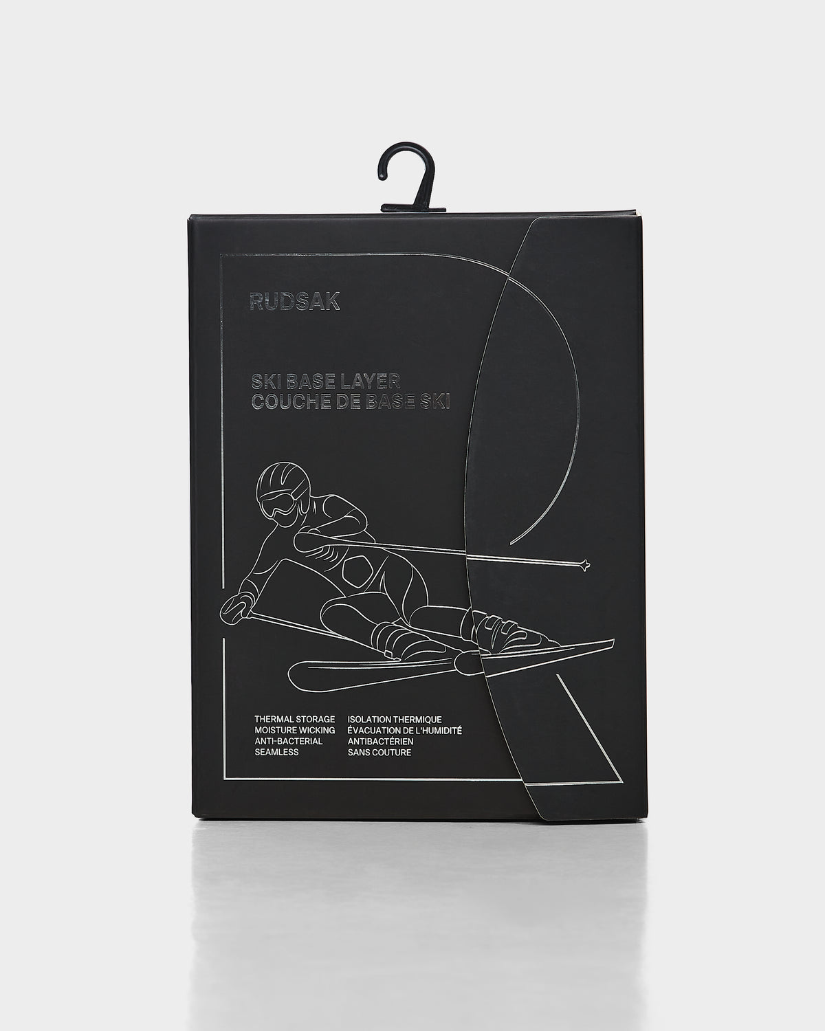 Black box with an outline of a downhill skier in motion. Text reads Rudsak and CARRIE - 8524619 Iceland, highlighting women’s thermal set and stretch leggings. Box features a handy hanging hook on top.