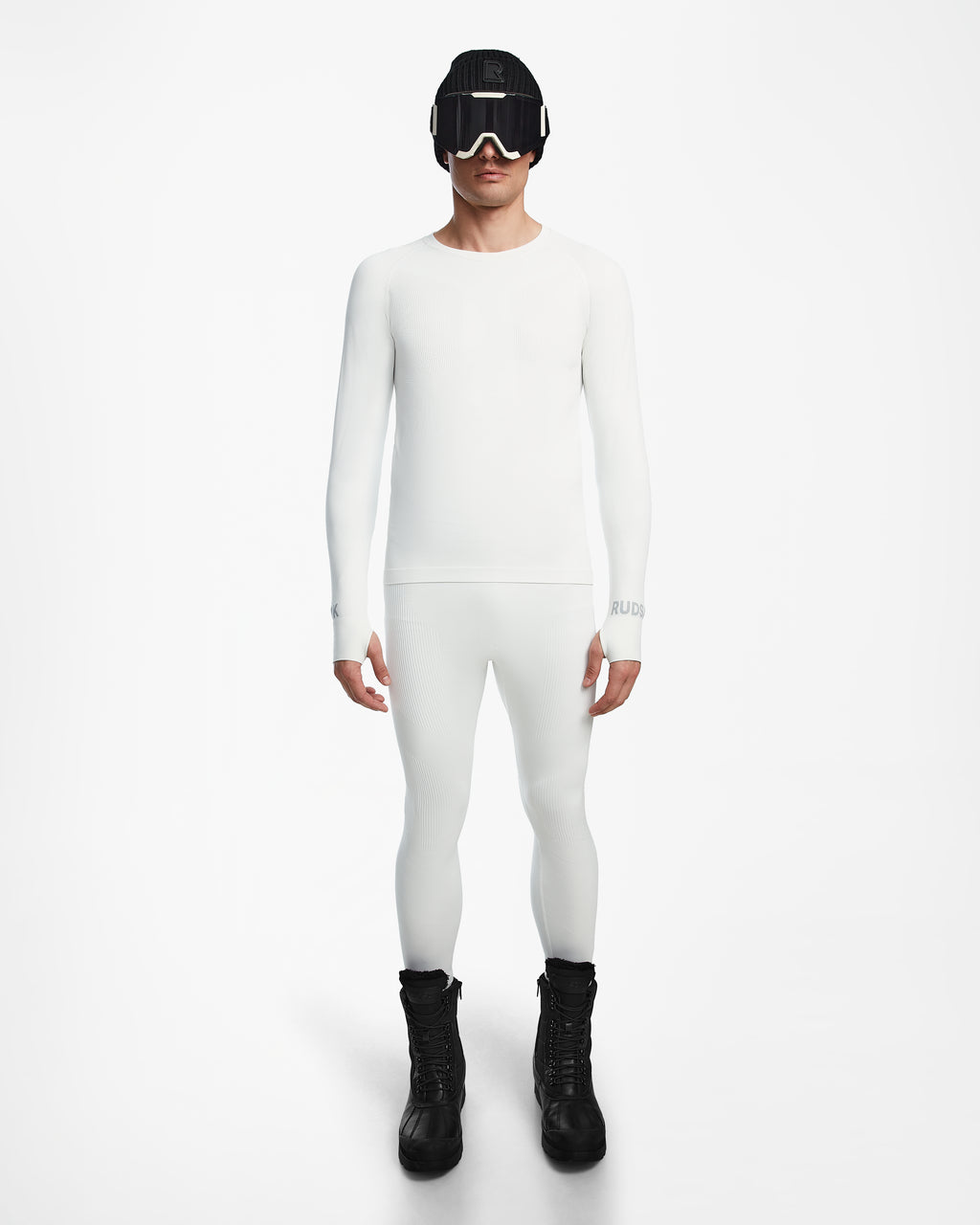 A person faces forward wearing Rudsak’s FRANC - 6524541 Iceland fitted white men’s thermal set as a ski base layer, styled with black snow boots, a black winter hat, and ski goggles against a plain white background.