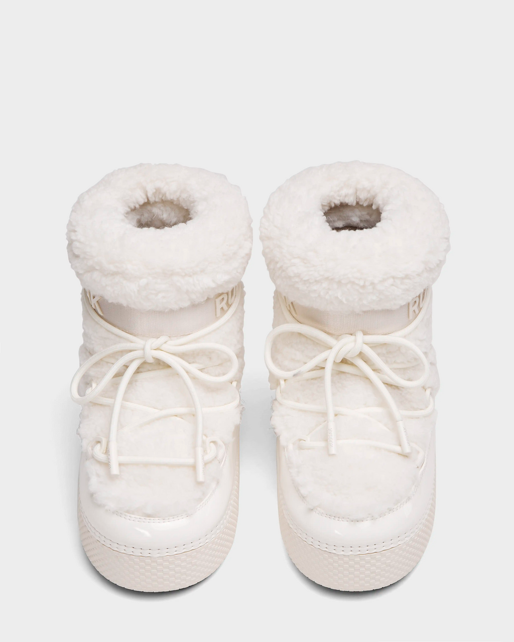The Rudsak KATHY Y - 1224500 Iceland boots are white, fluffy, water-repellent winter boots with thick soles and front laces. Seen from above on a light background, they feature a cozy, padded, and textured design.