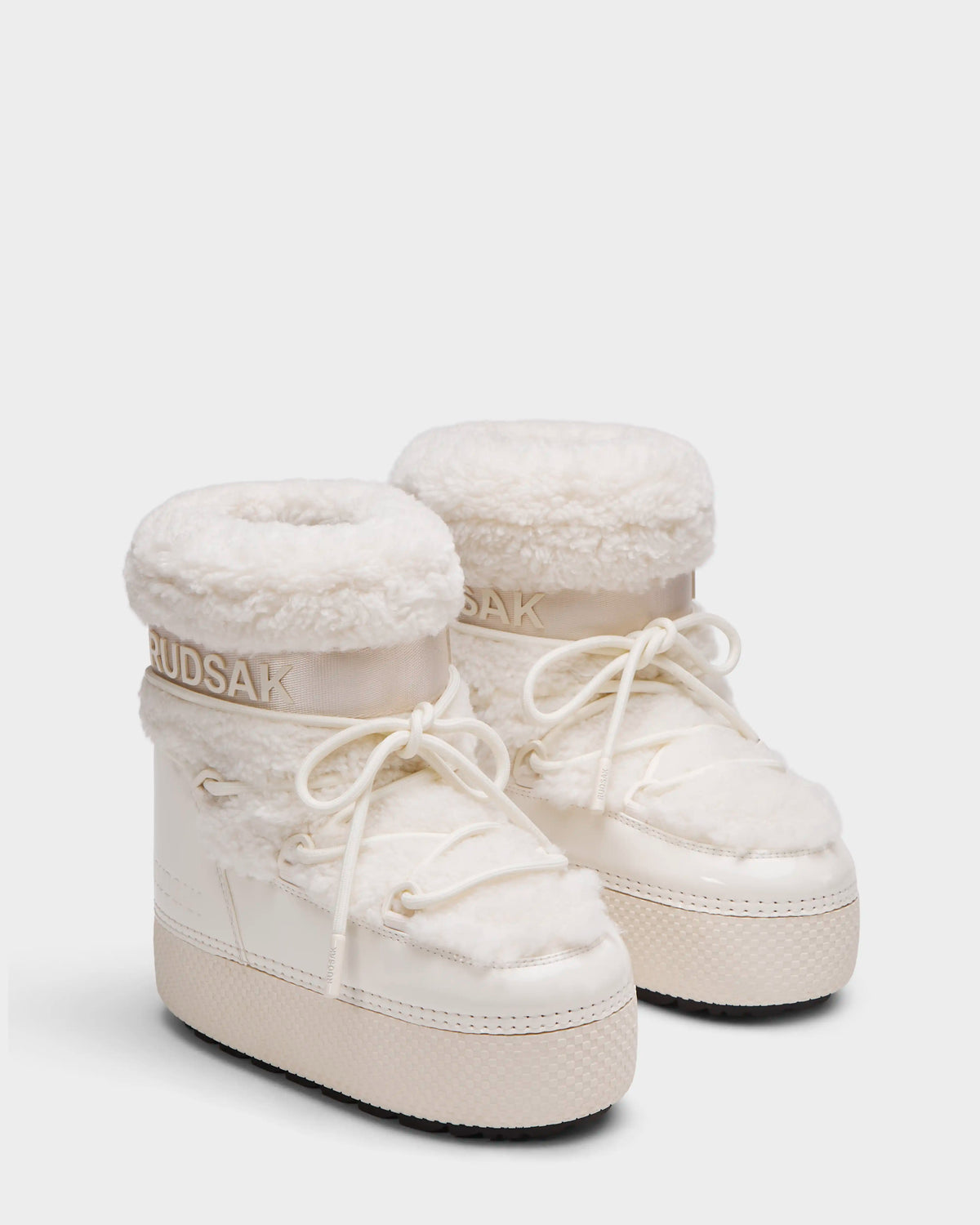 The KATHY Y - 1224500 Iceland by Rudsak are white winter boots with thick, textured soles, fluffy faux fur trim, water-repellent finish, laces, and Rudsak branding on the collar, shown on a plain white background.